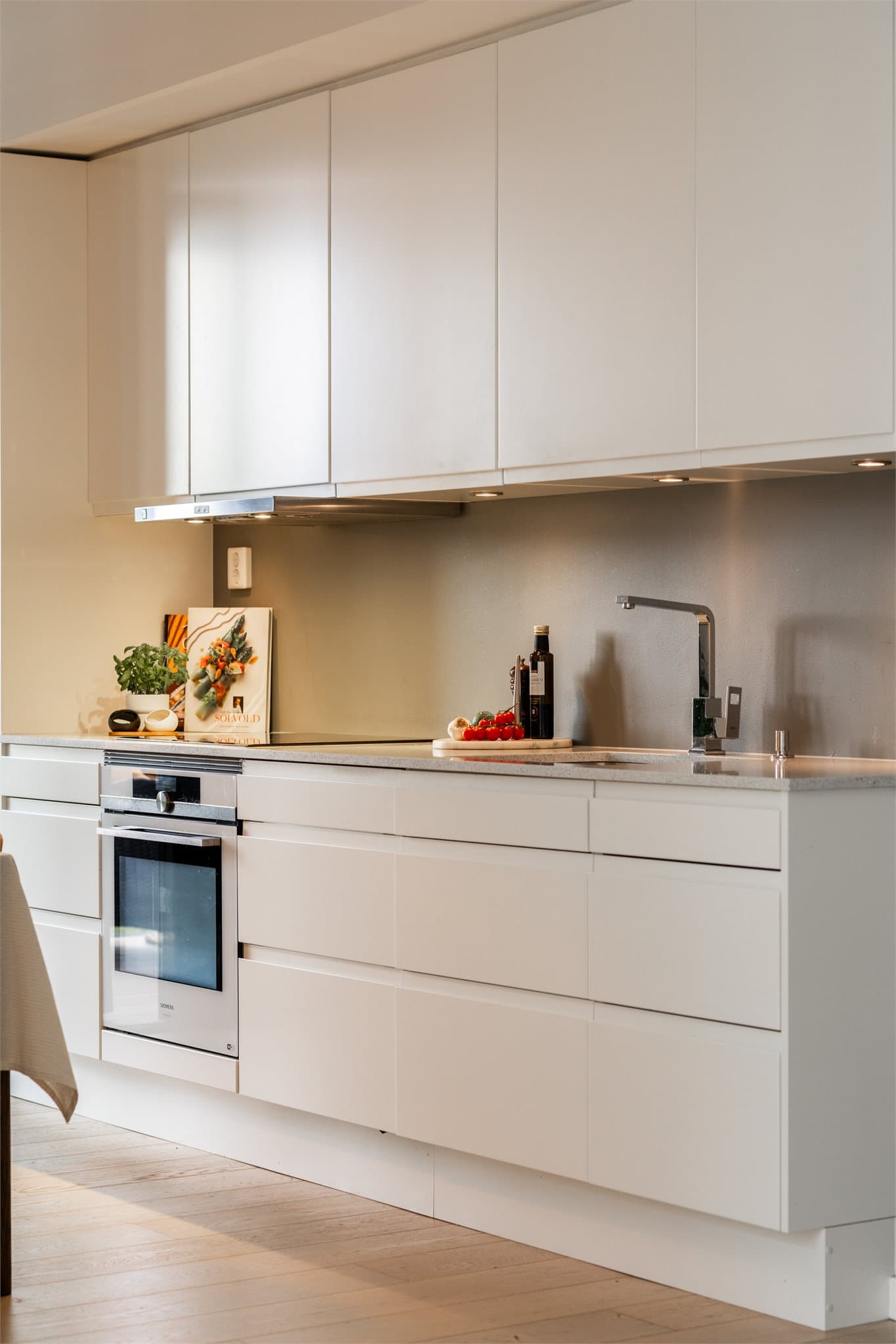 Integrerte hvitevarer med platetopp, komfyr, kombiskap og oppvaskmaskin. I tillegg er det kjøkkenviften koblet mot balansert anlegg, noe som sørger for godt avtrekk og godt inneklima.