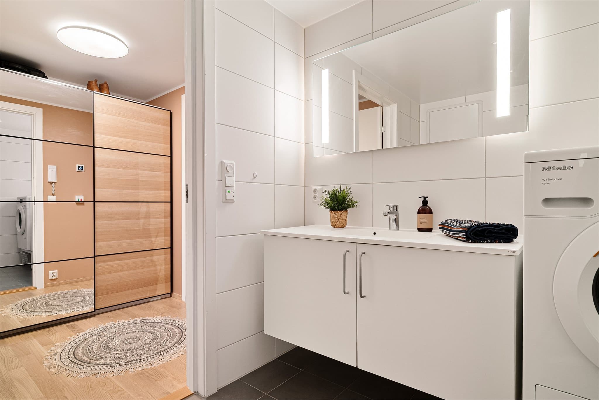 Badet har et moderne speil med integrert belysning.