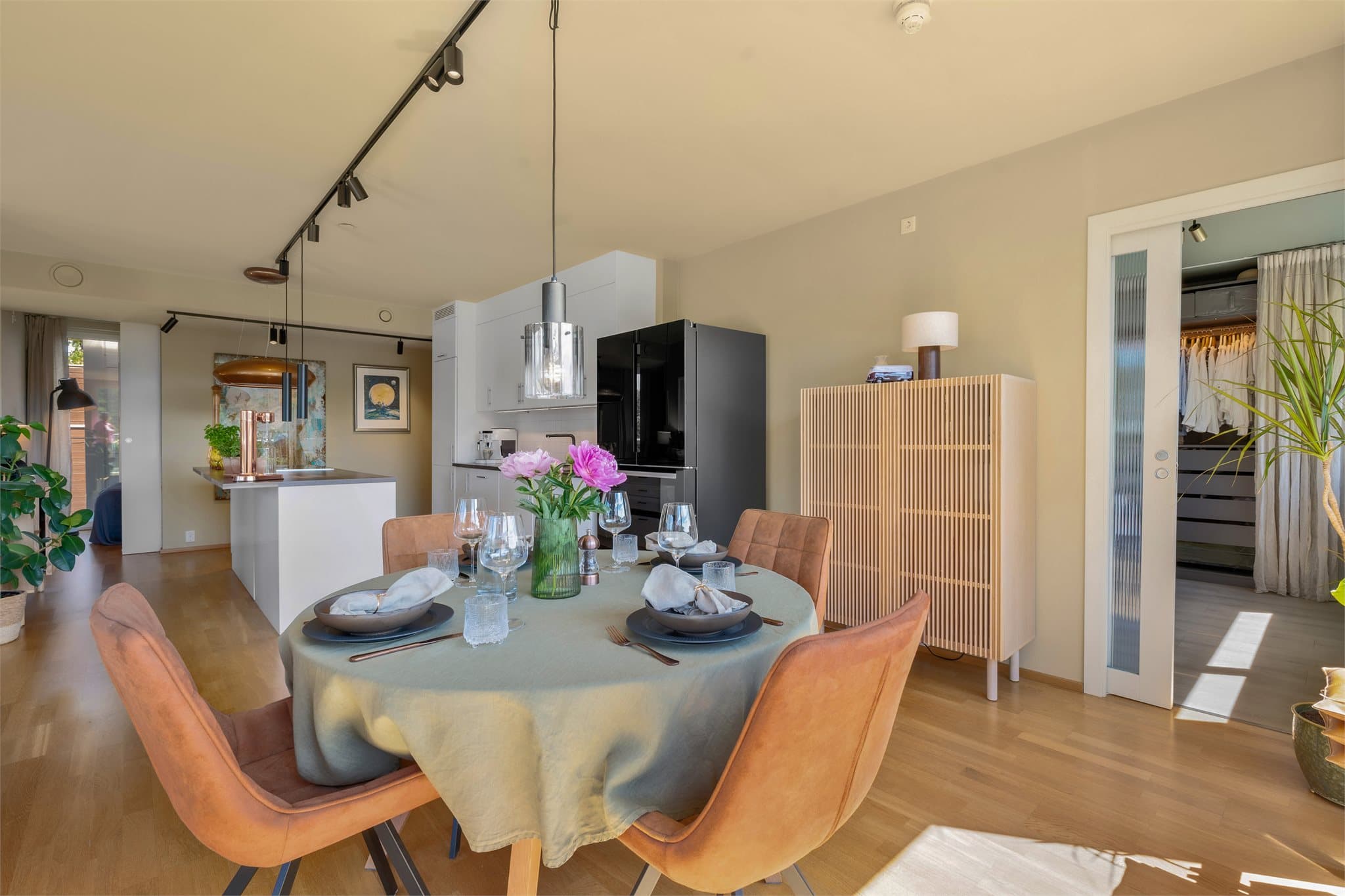 I tilknytning til spiseplassen finner man adkomst til hovedsoverommet via en moderne skyvedør med rillet glass. Den gjennomførte detaljen bidrar til boligens eksklusive uttrykk og understreker de tidsriktige material- og designvalgene.