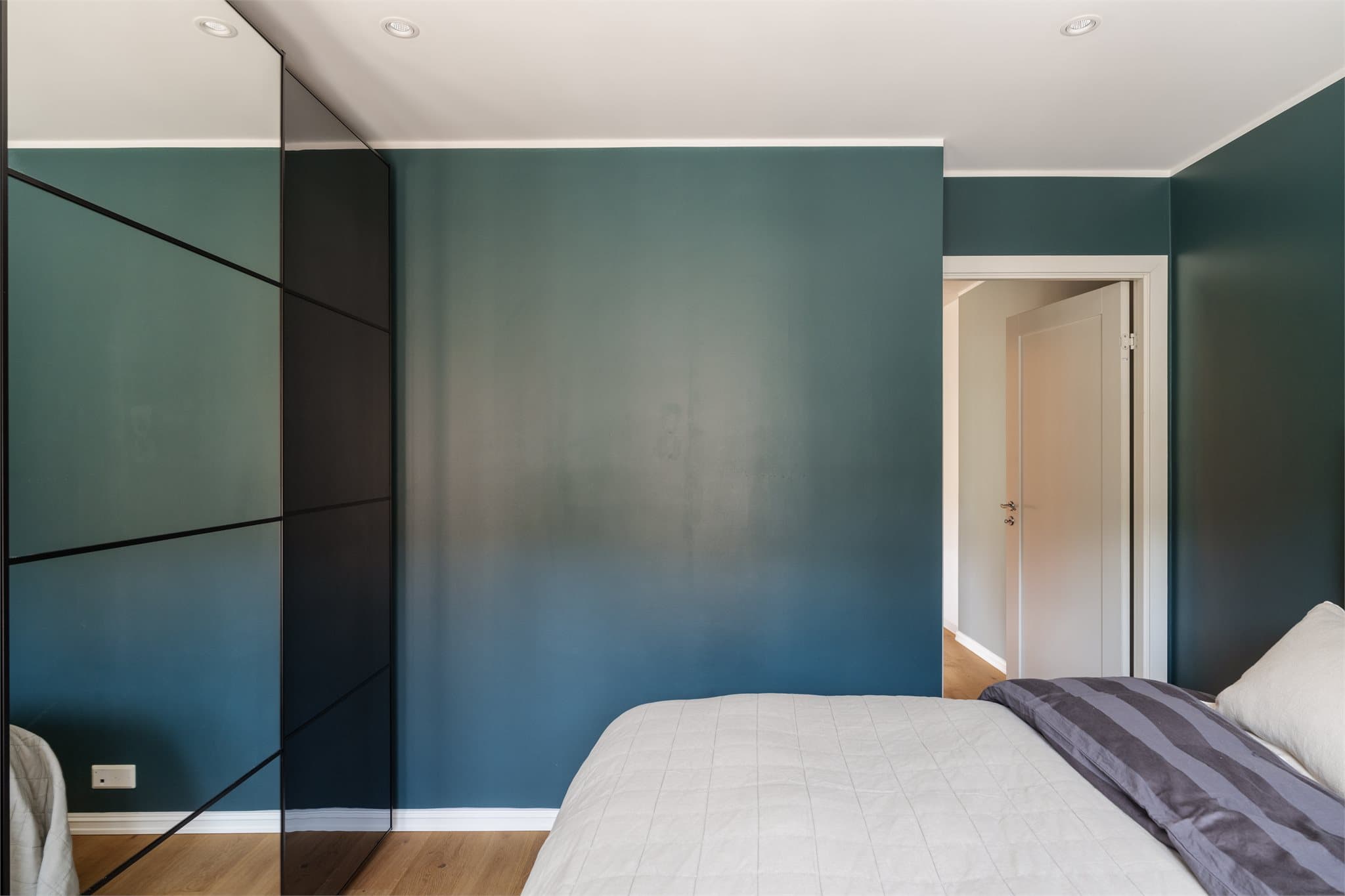 Rommet er romslig med god plass til dobbeltseng og øvrig møblering. Praktisk skyvedørsgarderobe med speilfronter sørger for gode oppbevaringsmuligheter, og downlights i taket gir et moderne preg.