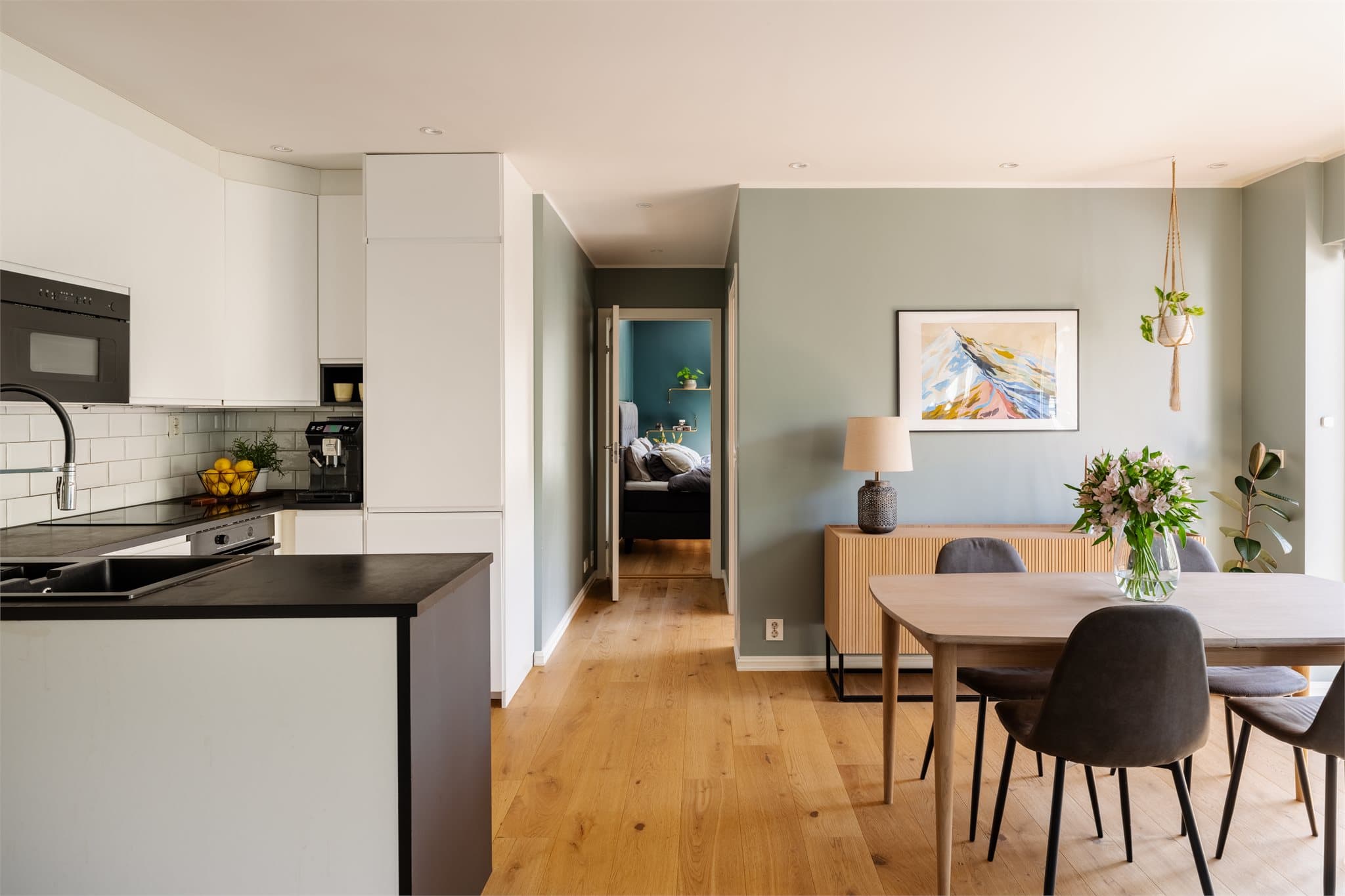 Enstavs parkett og vegger malt i en harmonisk, dus grønn fargetone gir rommet et moderne og behagelig uttrykk.