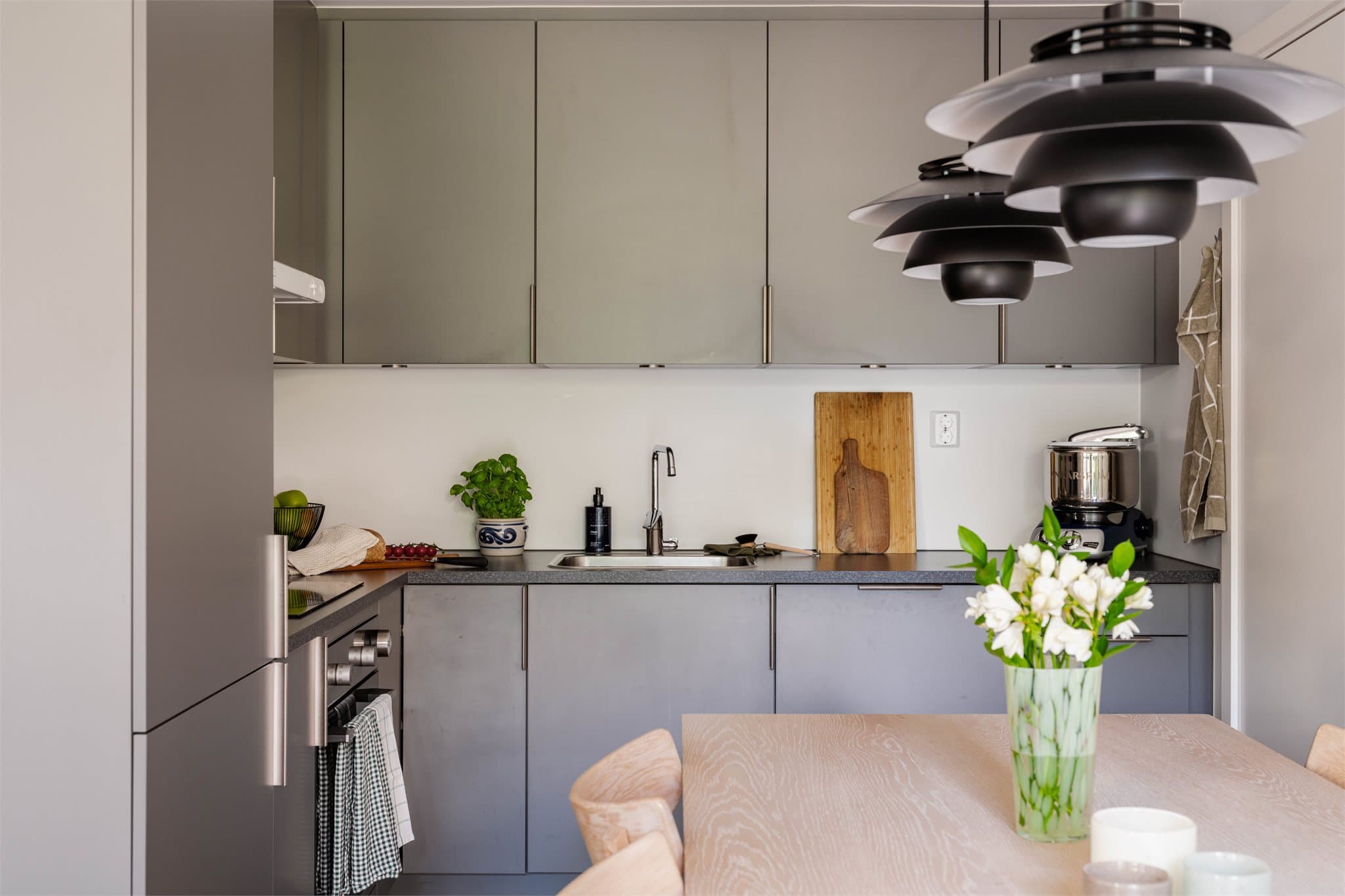 Stilrent kjøkken med slette fronter og laminat benkeplate.