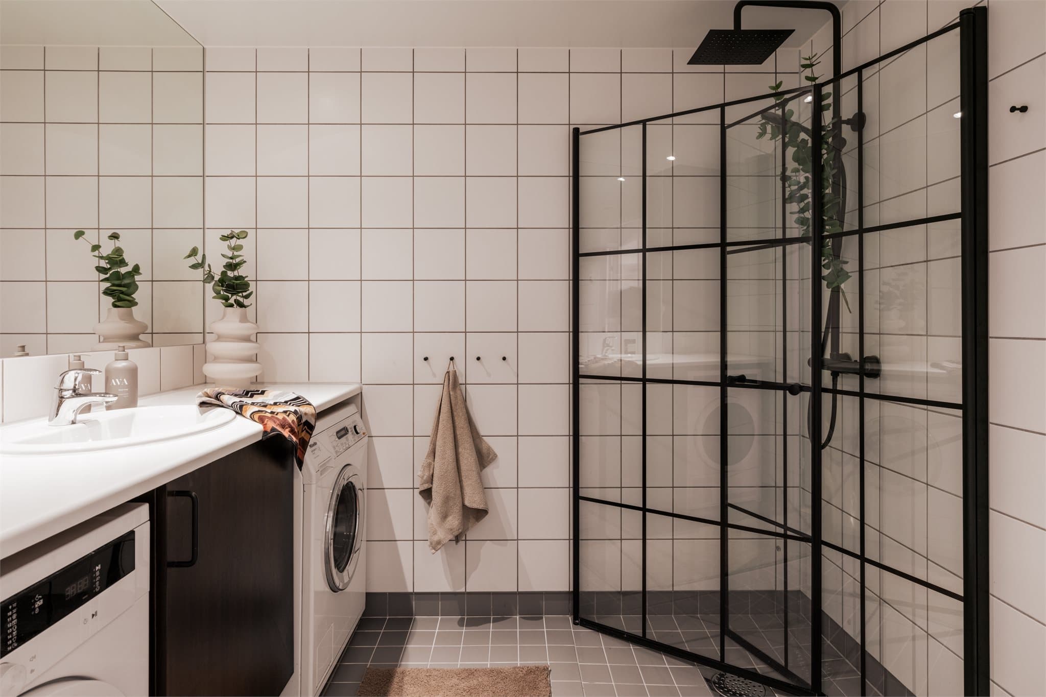 Badet har lyse, flislagte overflater og varmekabler i gulvet.