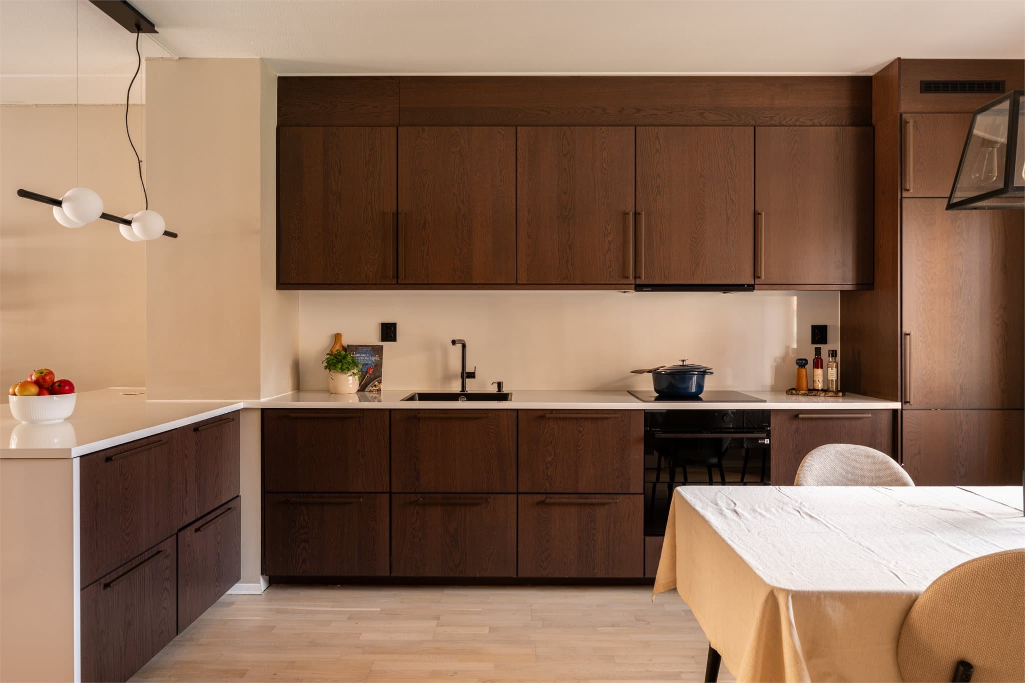 Et gjennomført kjøkken med mye skap- og benkeplass.