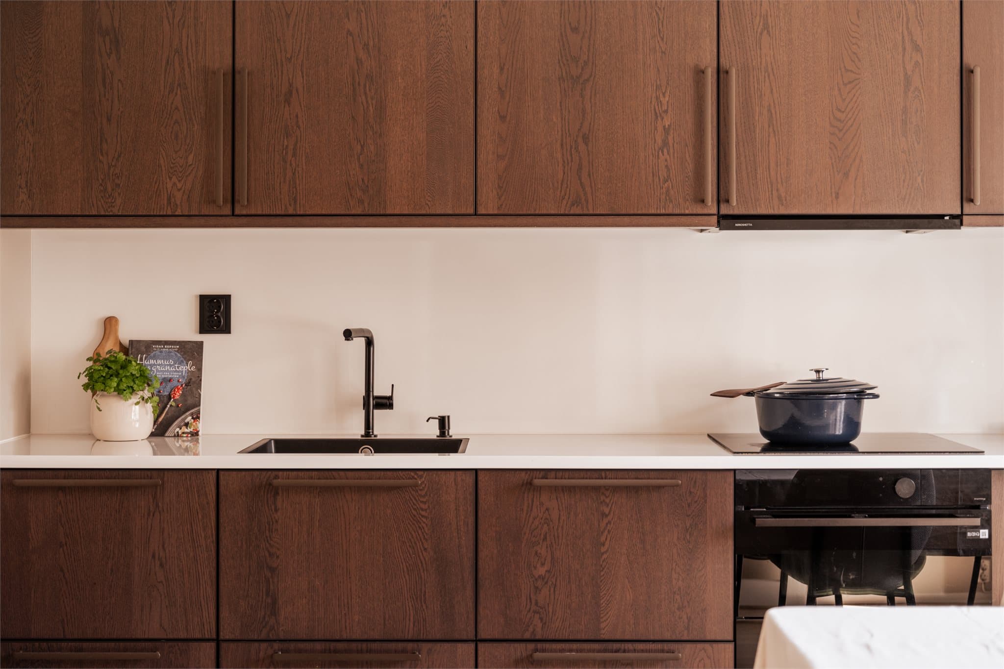 Benkeplate i lys laminat kombinert med mørke fronter skaper et elegant uttrykk.