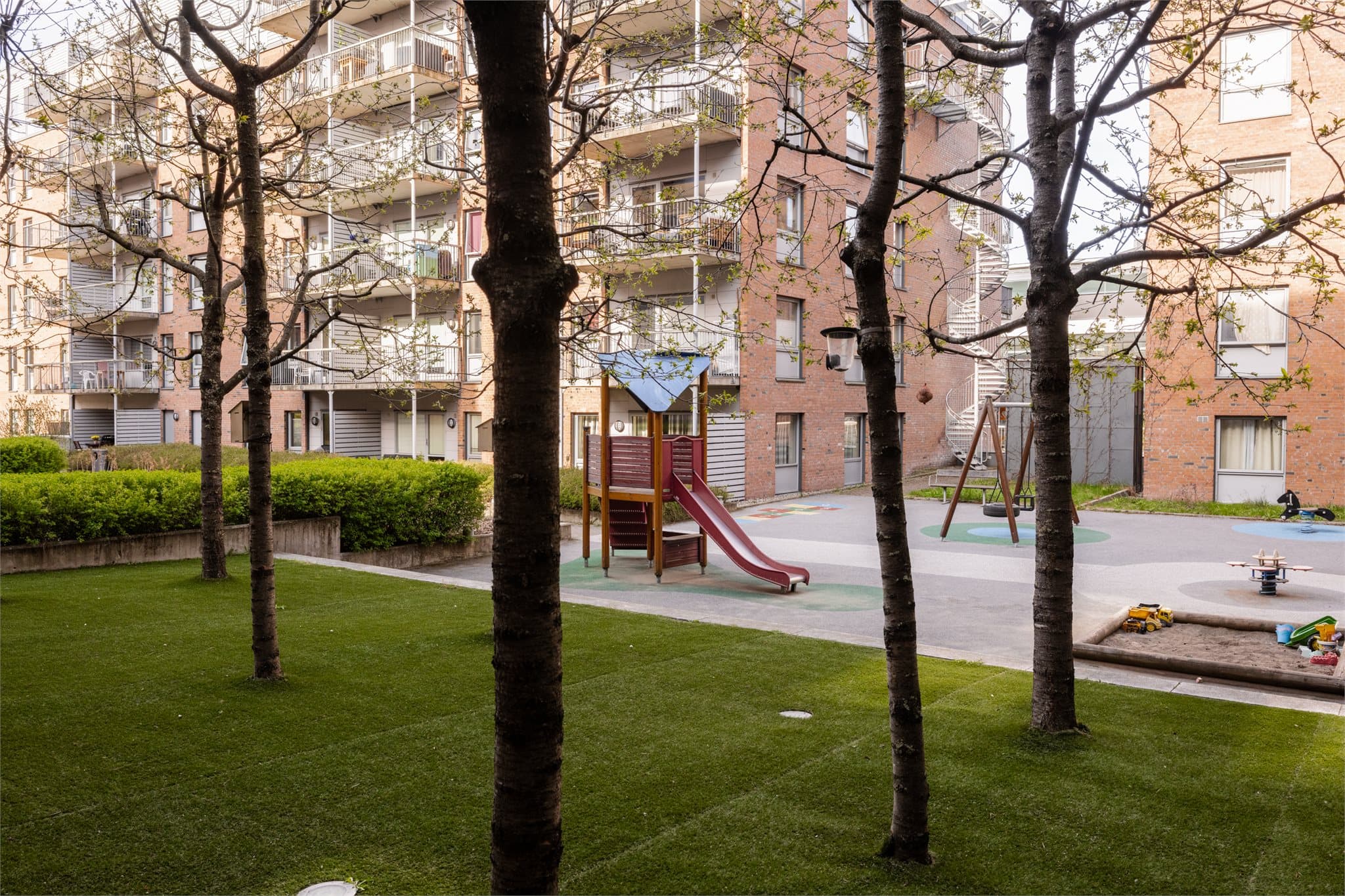 Bakgården er stor og frodig med mange trær.