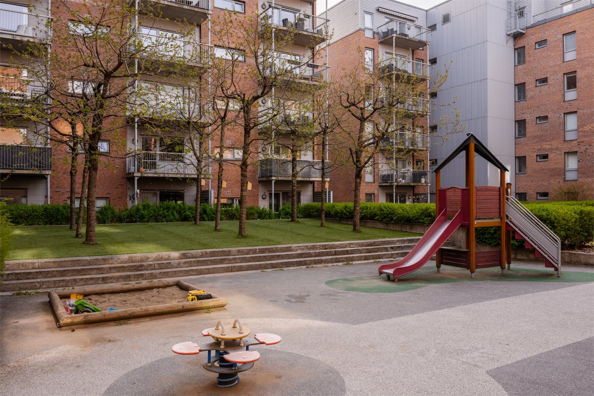 Leiligheten vender ut mot et flott, skjermet gårdsrom med lekeplass for de minste.