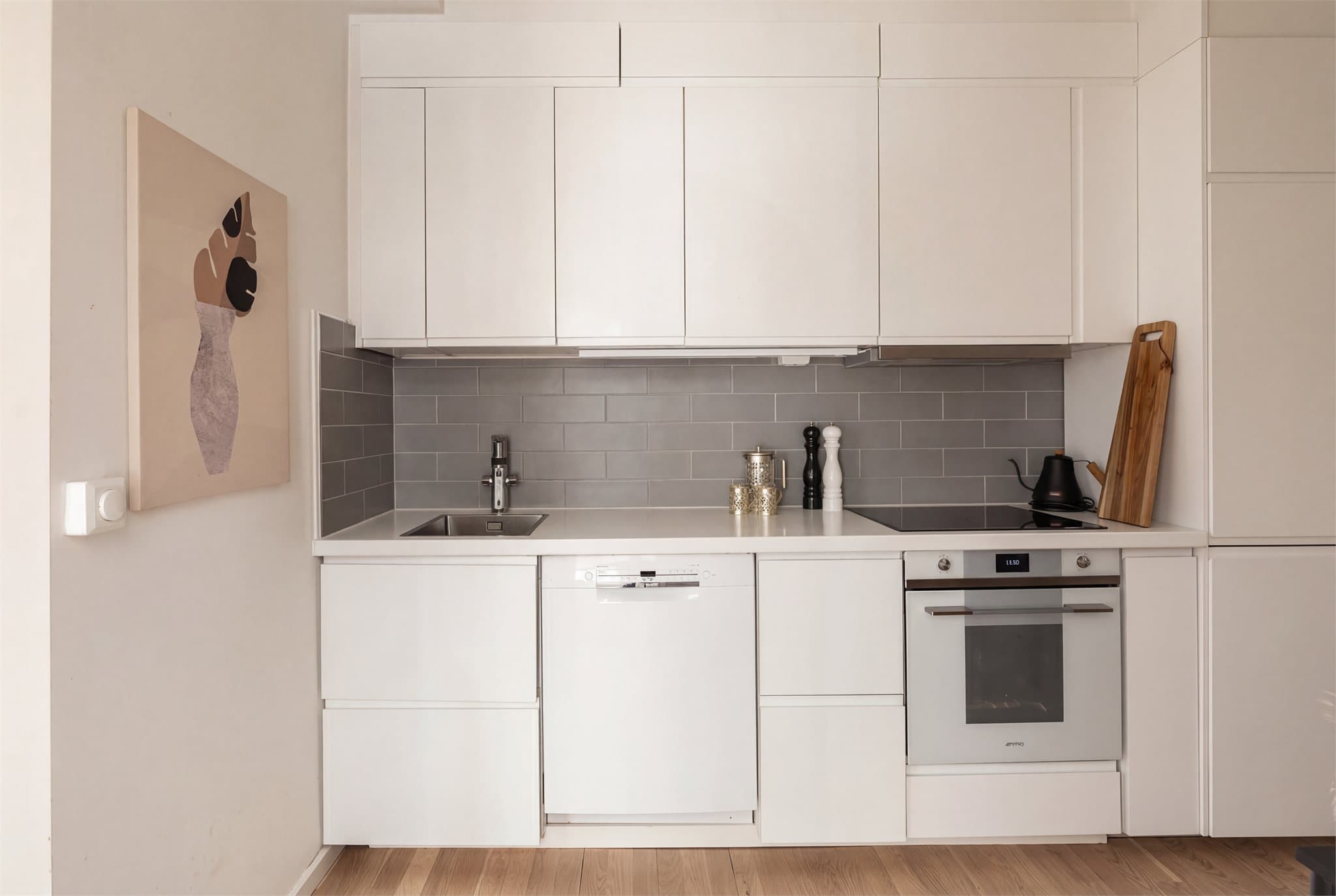 Kjøkkenet disponerer integrert platetopp, stekeovn, kjæl/fryseskap, kullfilterventilator, samt oppvaskmaskin. Bildet er AI-redigert.