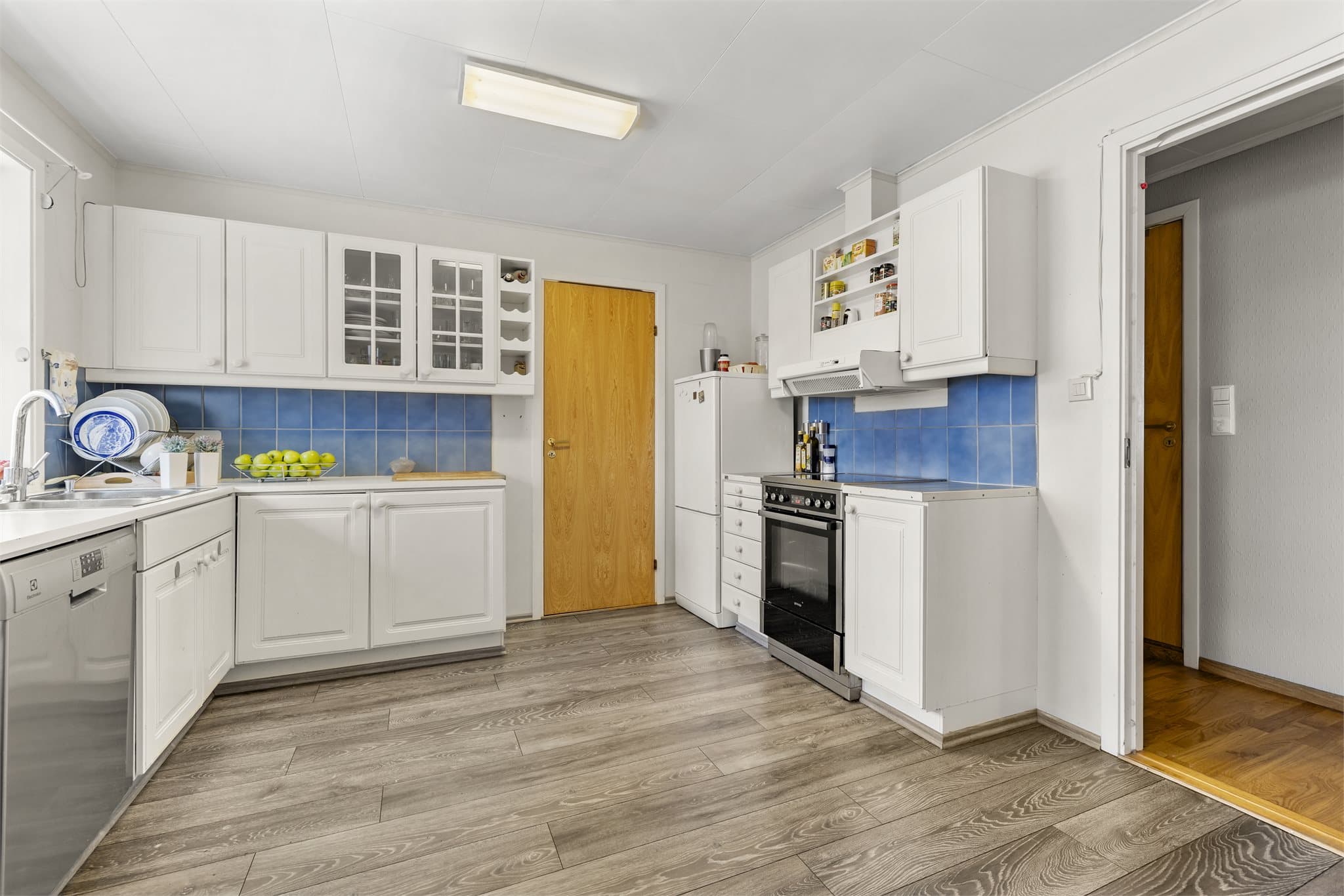 Lyst kjøkken med gjennomgående innredning og god arbeidsflate.