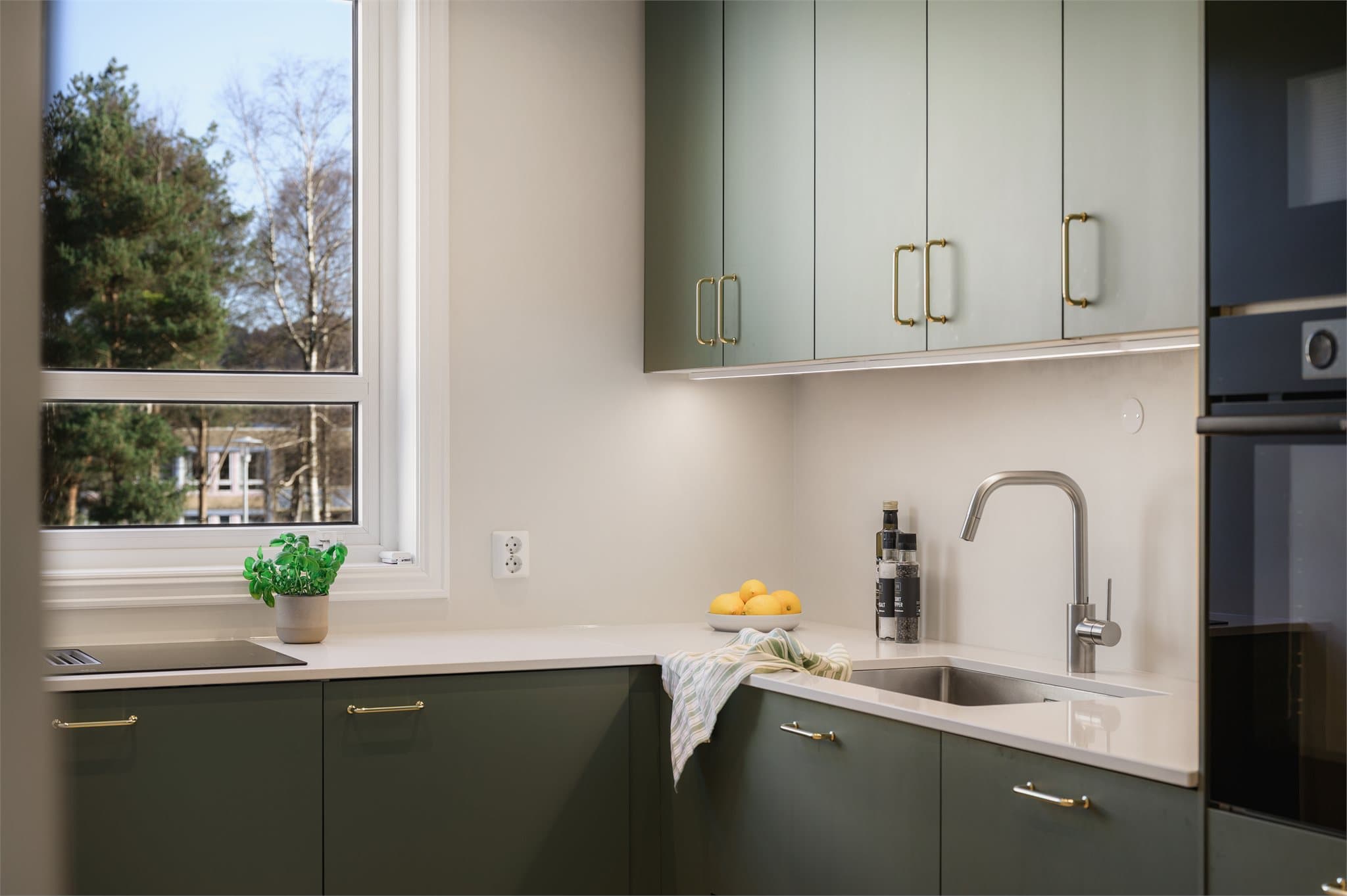 - Kjøkkeninnredning med glatte fronter og benkeplate i kvartskompositt -