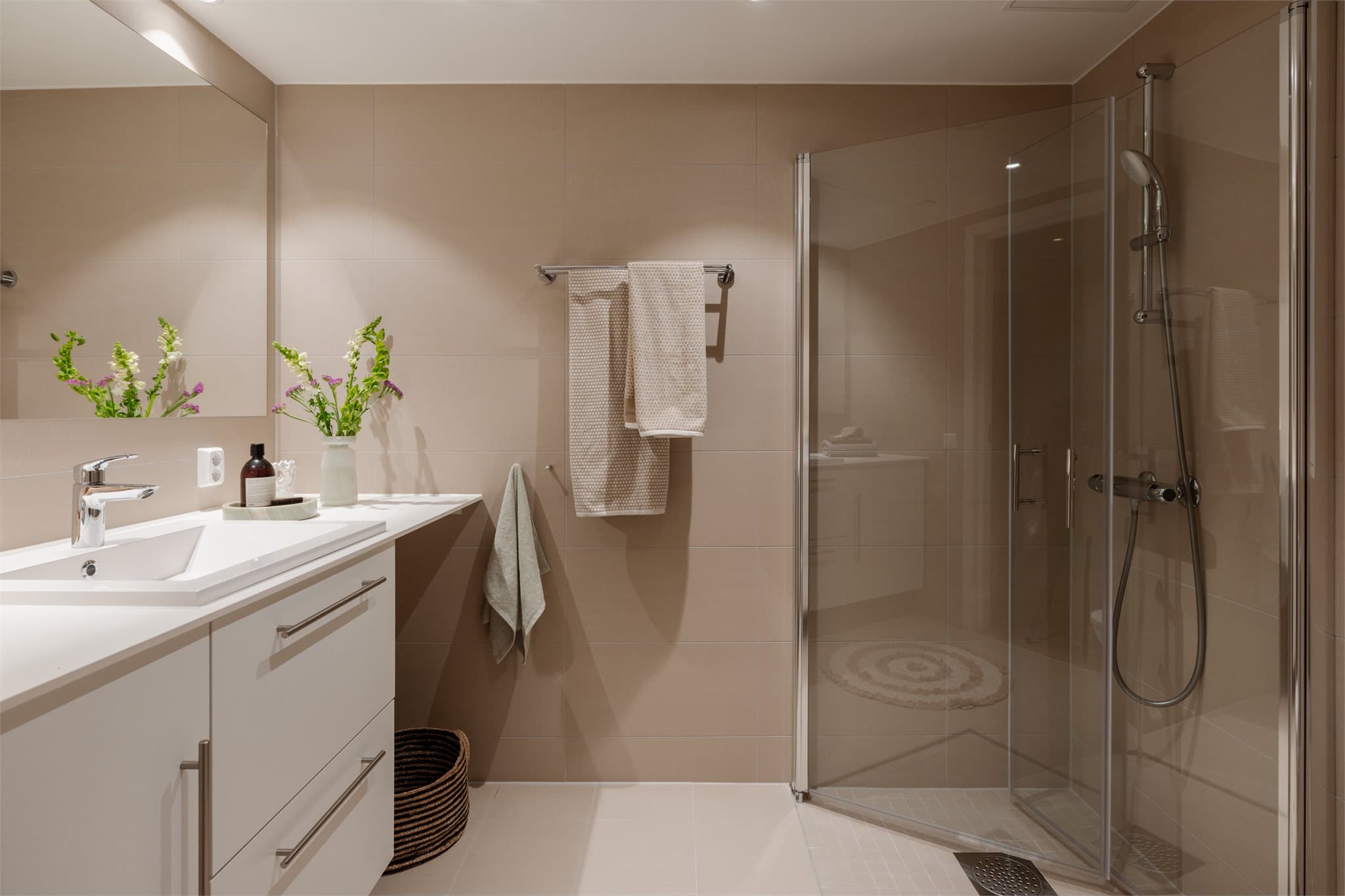 Badet har store, lyse fliser og deilig varme i gulvet.