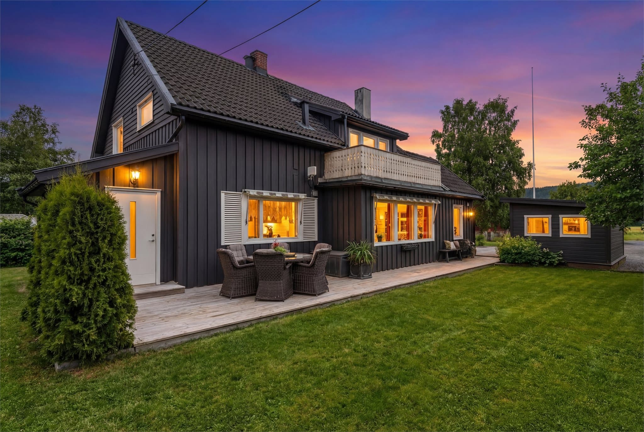 Boligen har en skjermet hage. Digitalt skumringsbilde.