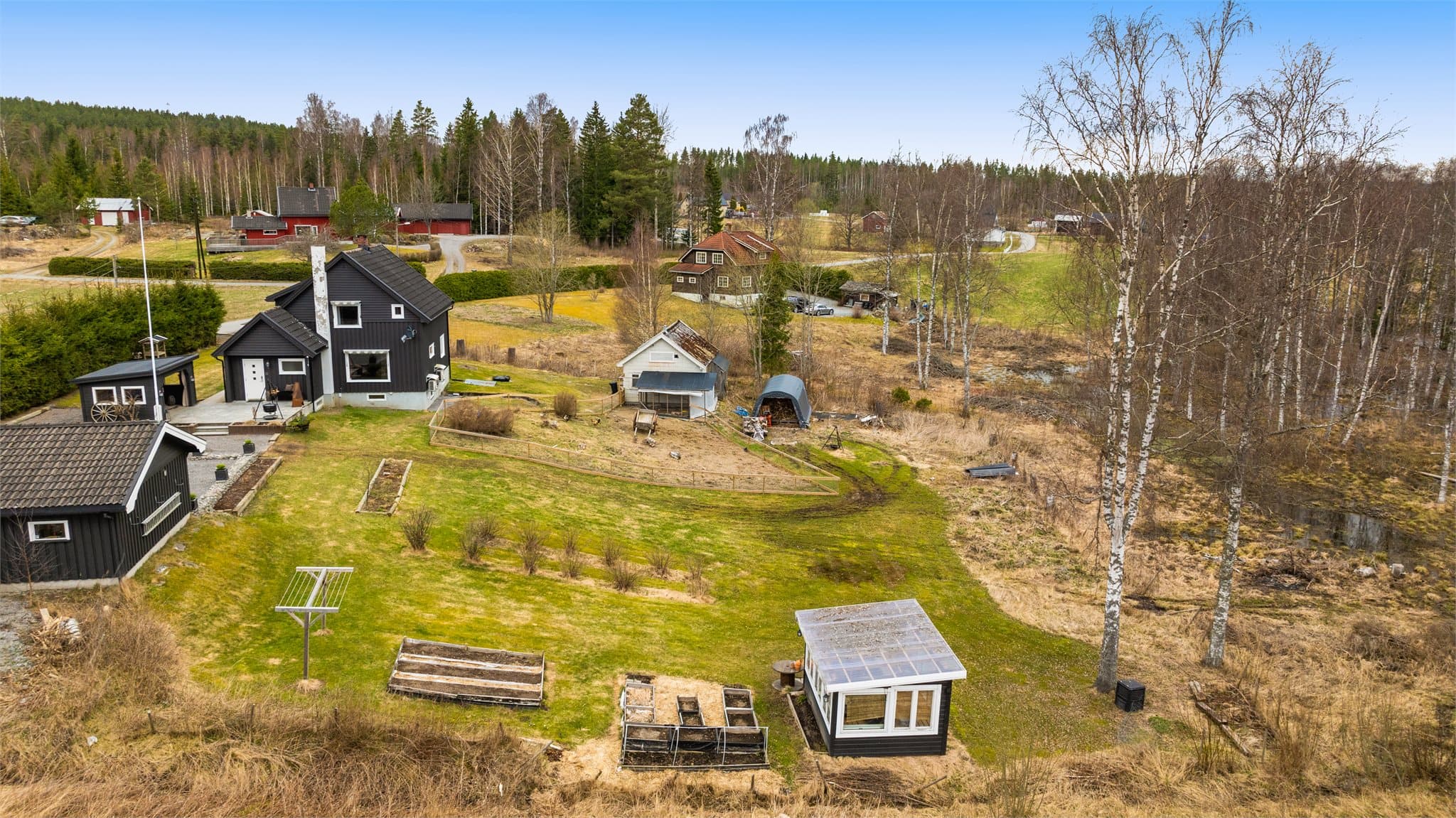 Stor og romslig tomt med bl.a. drivhus og hønsehus.