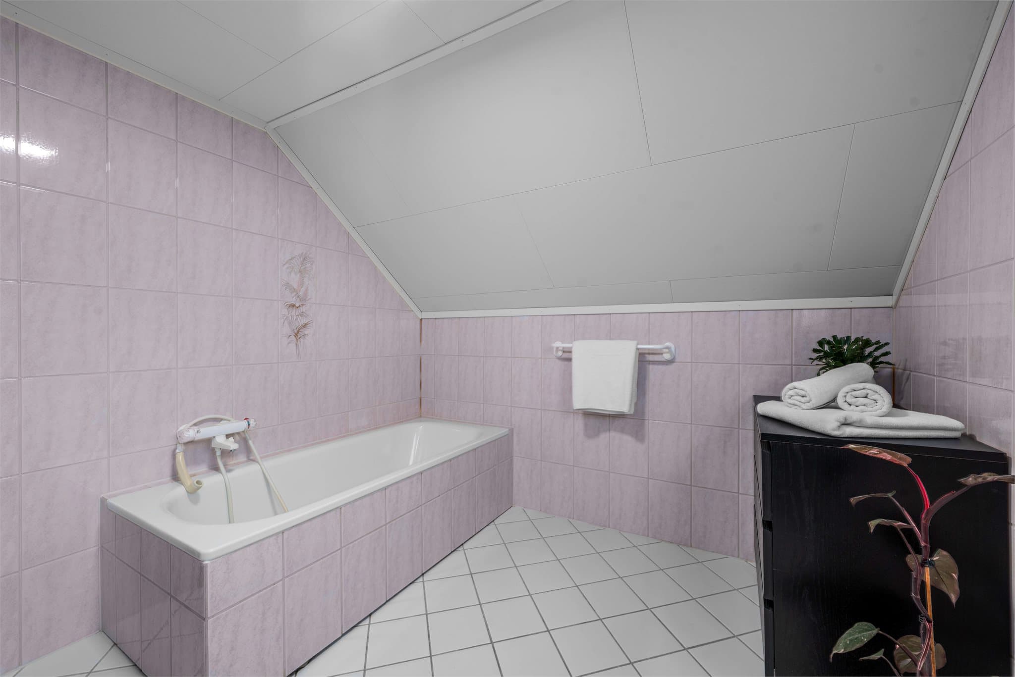 Badet er innredet med dusjkabinett, badekar og helservant på skuffeseksjon.