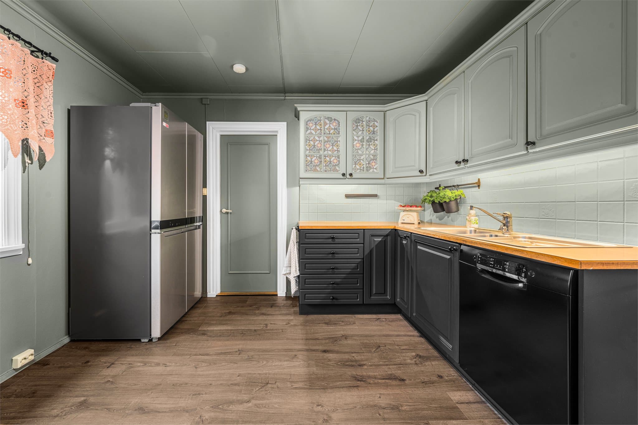 Kjøkkeninnredningen har profilerte, malte fronter.