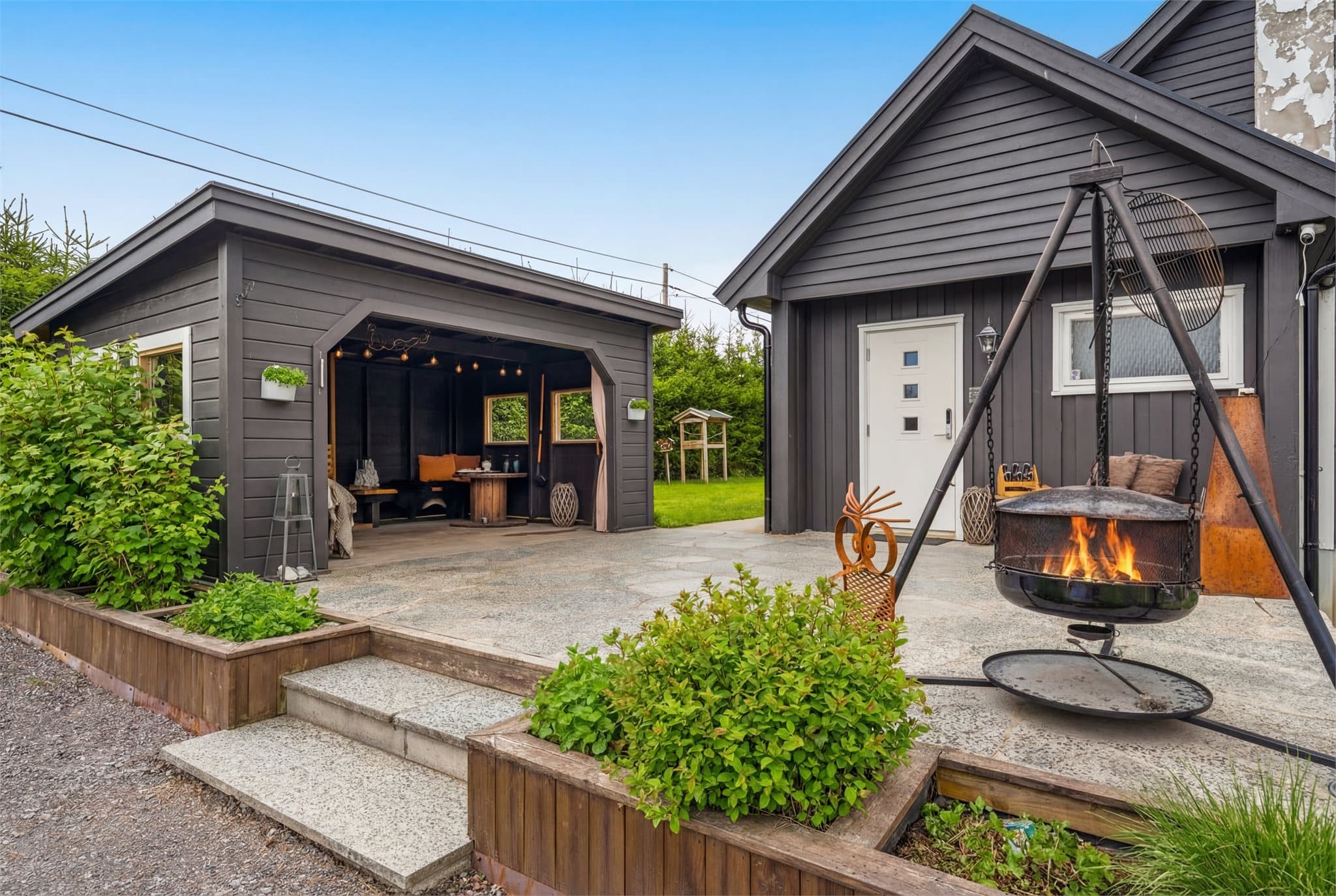 Tomten har gruset gårdsplass og et opphøyd inngangsparti hvor det bl.a. er en hyggelig hagestue.