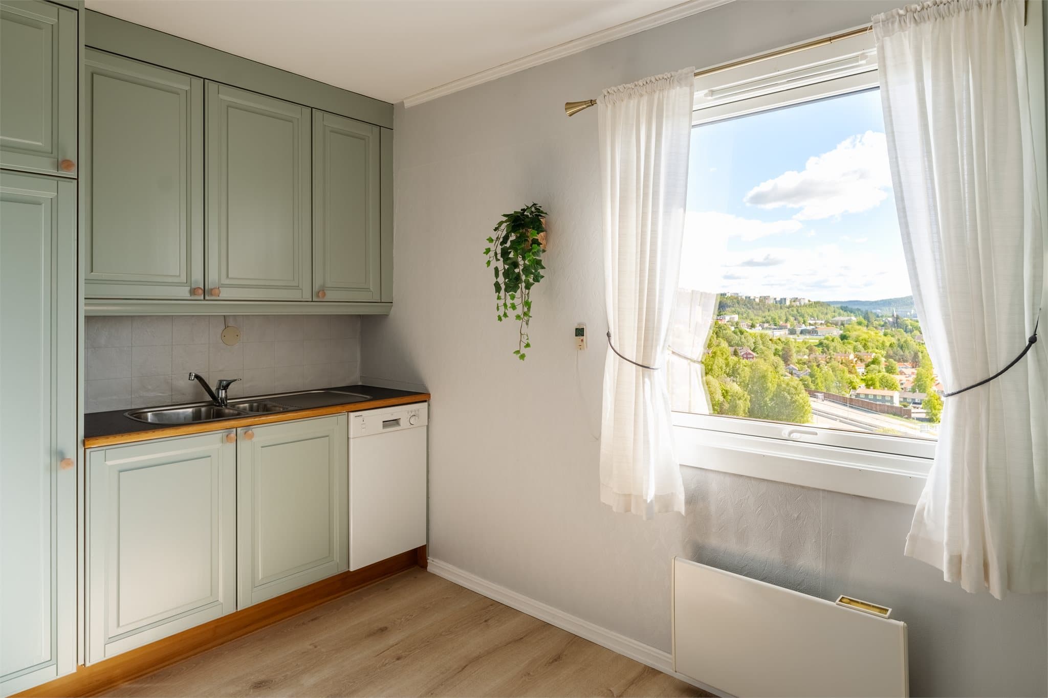 Innredningen har malte profilerte skapfronter og benkeplater av laminat.