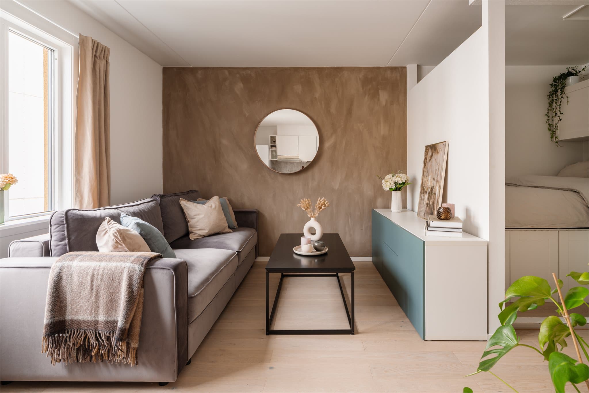 En av veggene i stuen har en malt overflate som gir rommet særpreg og dybde.