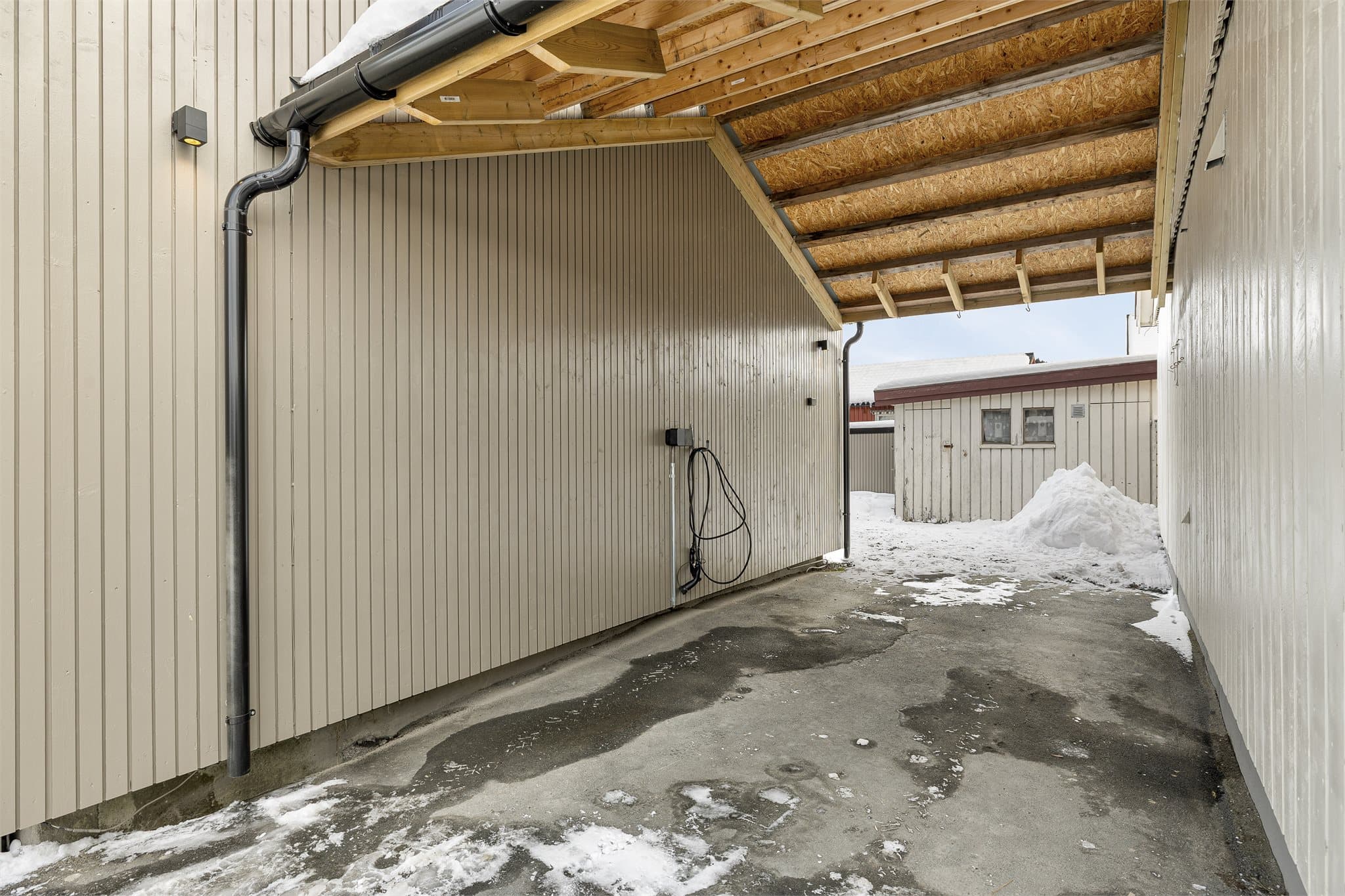 Carport med overbygg som gir værbeskyttet parkering.