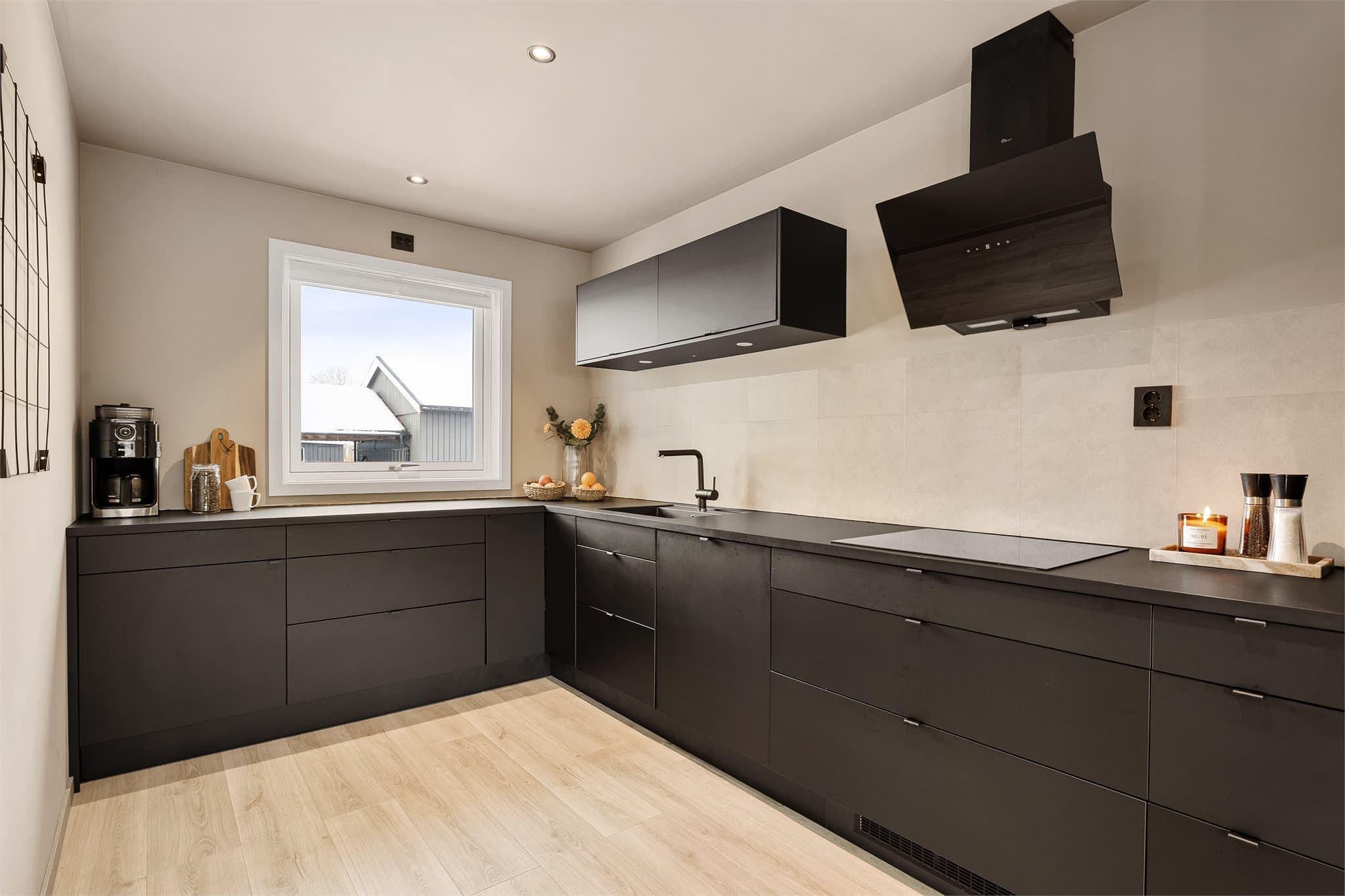 Lekkert Epoq-kjøkken fra 2022 hvor de sorte frontene viderefører boligens gjennomgående detaljer.