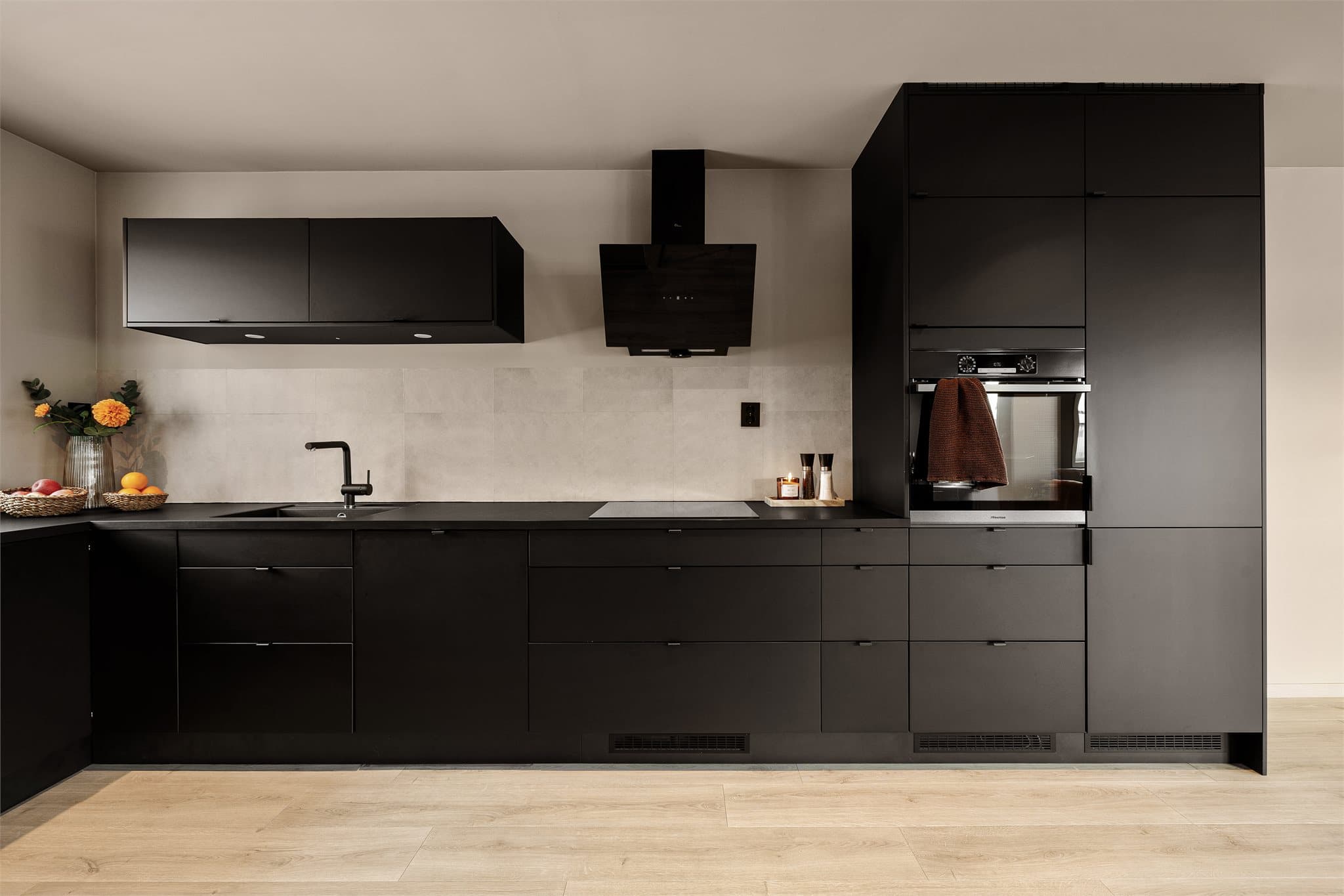 Et stilrent og gjennomført kjøkken med god skap- og benkeplass.