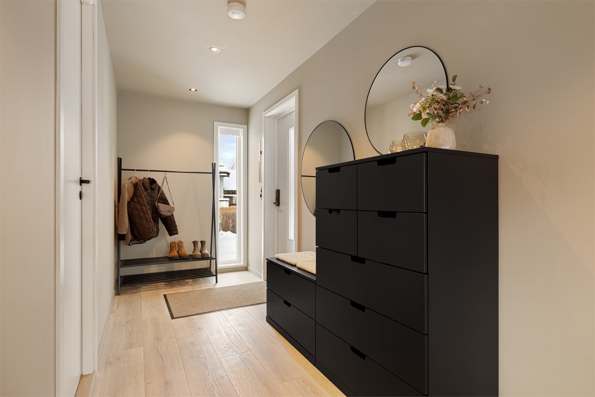 Innbydende og delikat entré med gode muligheter for oppbevaring av yttertøy.