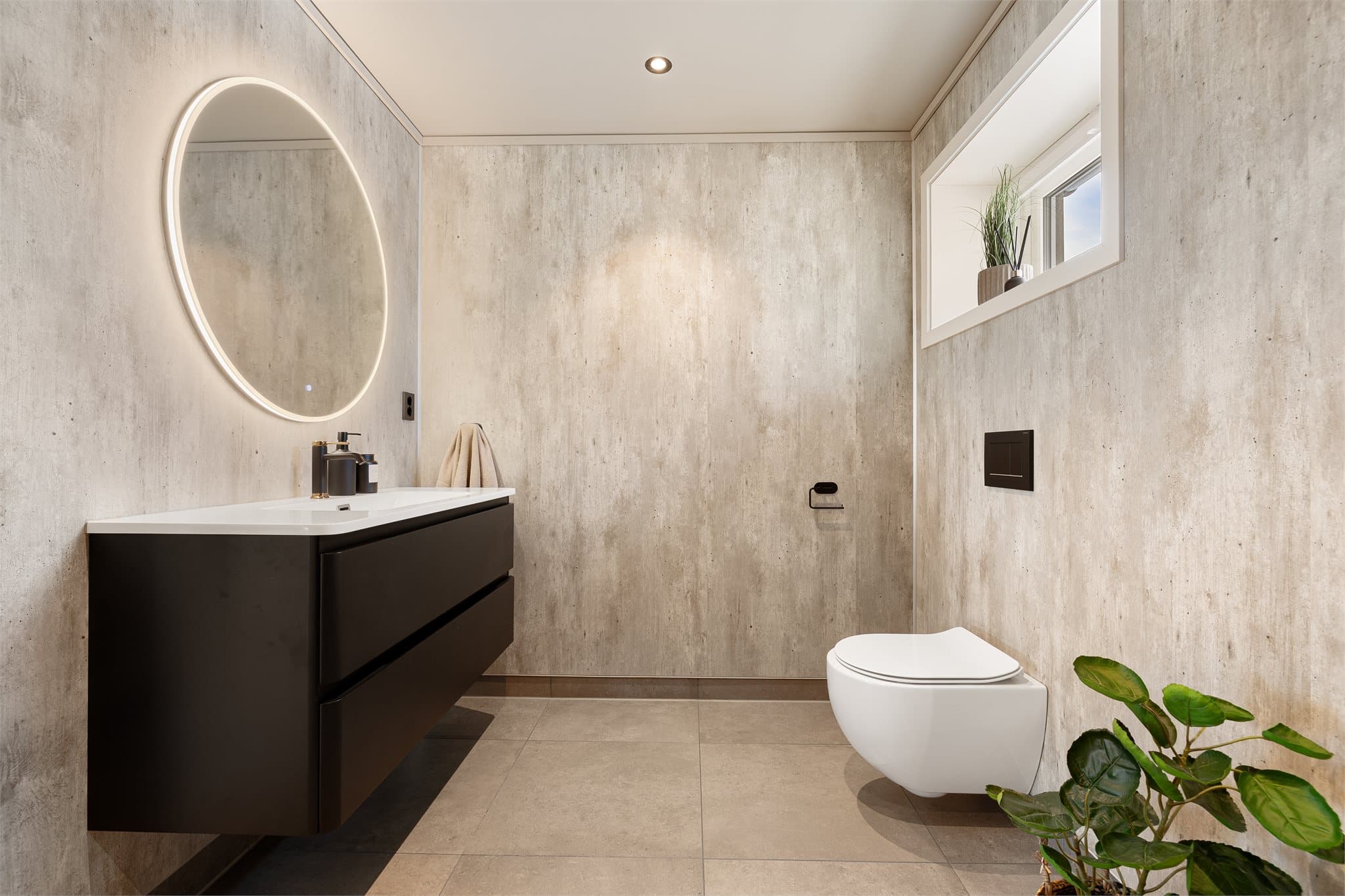 Badet har en lun fargepalett, gulvvarme og downlights som gir en rolig og innbydende stemning.