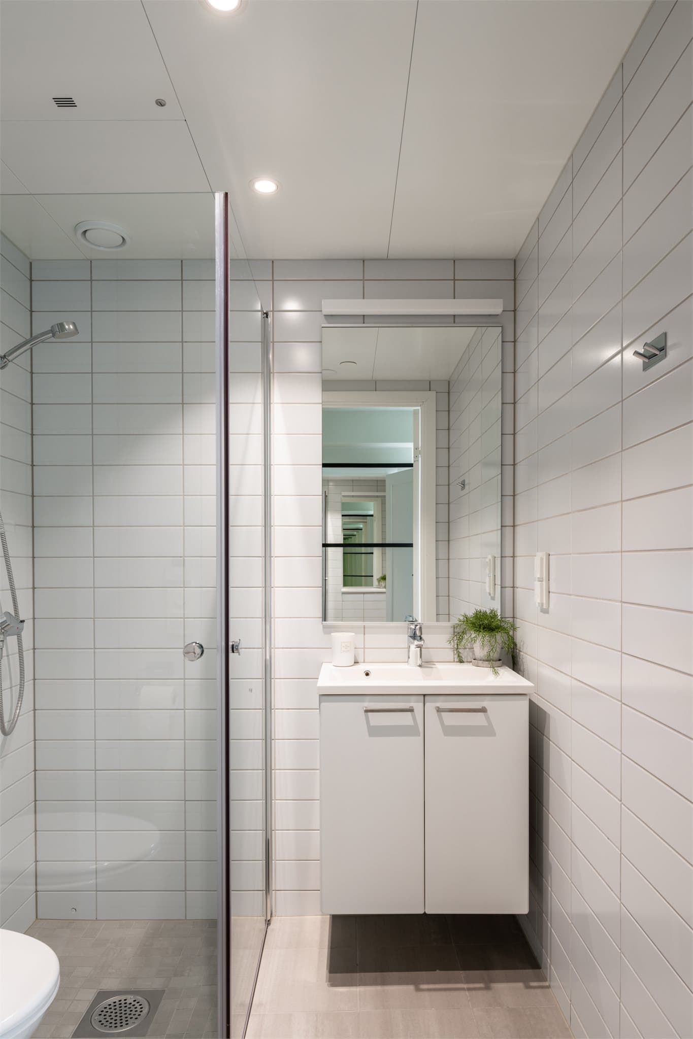 Et lyst, flislagt baderom med lun varme i gulvet.