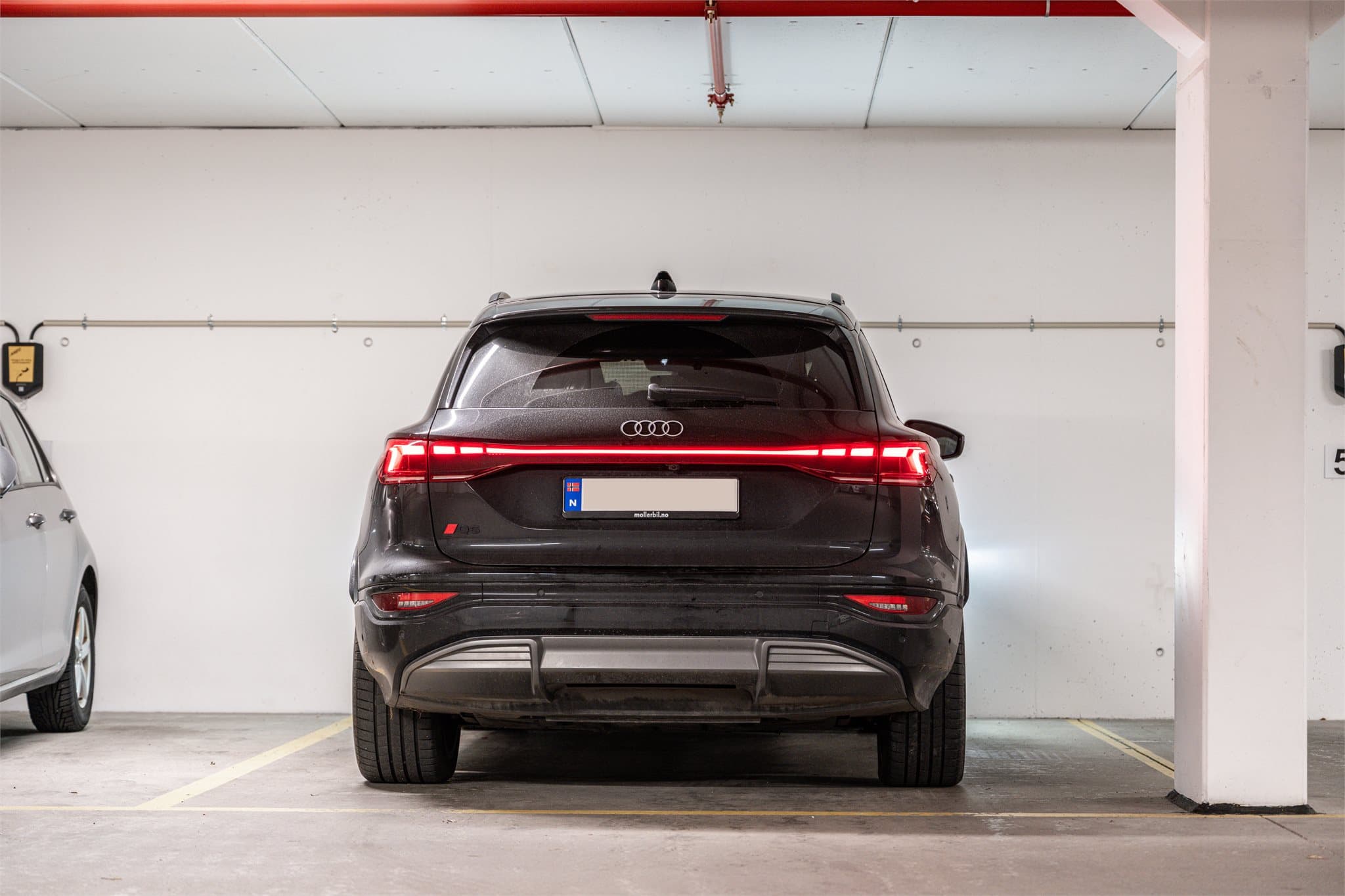 Det medfølger en ekstra bred parkeringsplass i lukket anlegg.