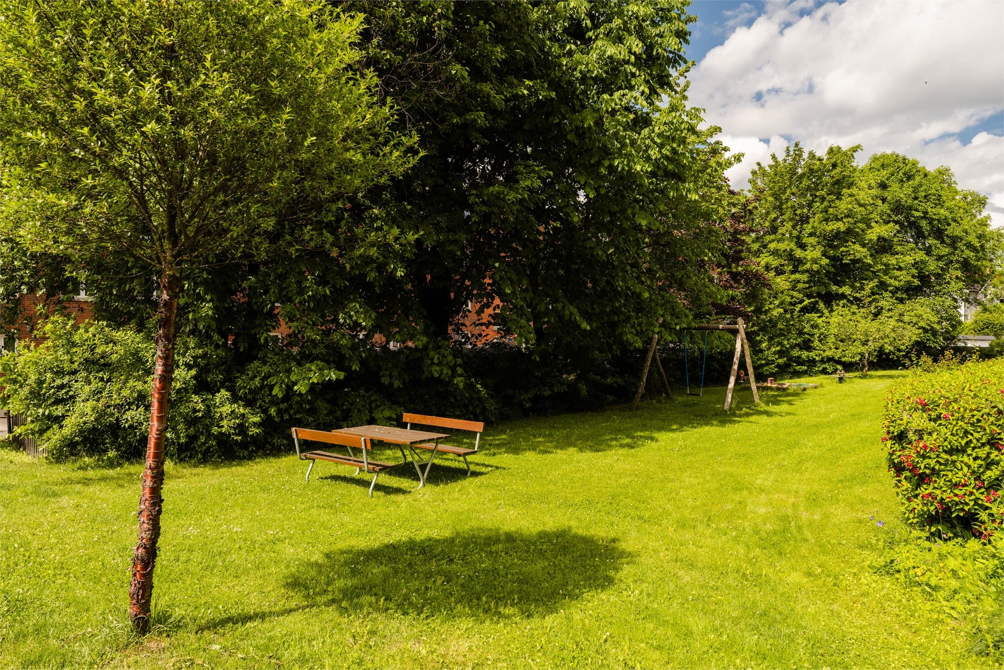 Store, grønne fellesarealer med sittegrupper og lekeplass.