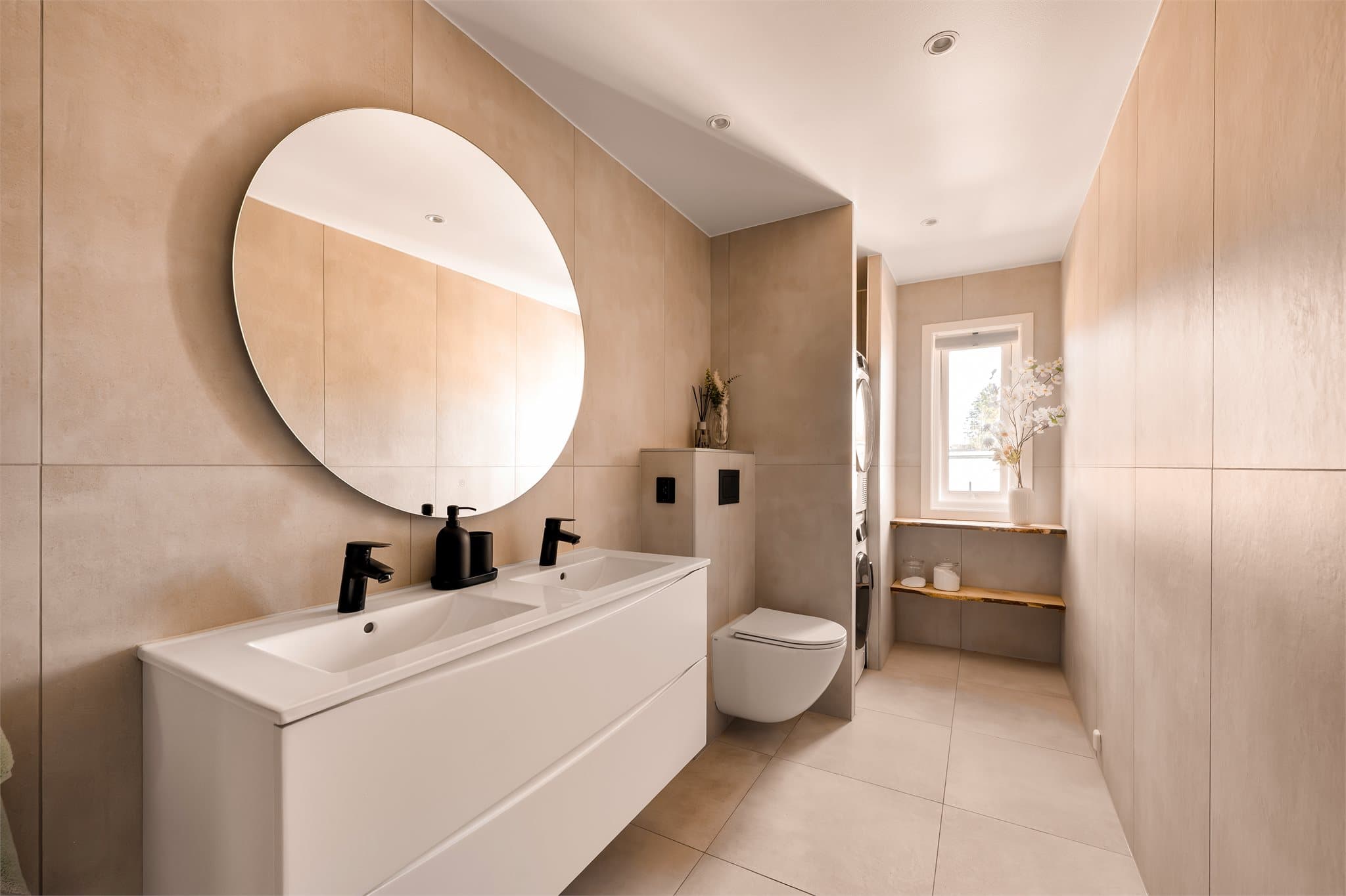 Badet ble totalrenovert i 2025, og fremstår lyst, delikat og praktisk. Rommet har opplegg for både vaskemaskin og tørketrommel.