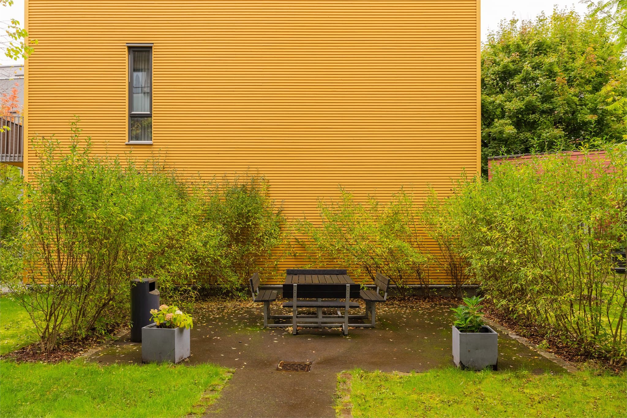 Felles tomt for borettslaget opparbeidet med gressplen, tær, prydbusker, lekeapparater for de minste, sykkelparkering og asfalterte internveier.