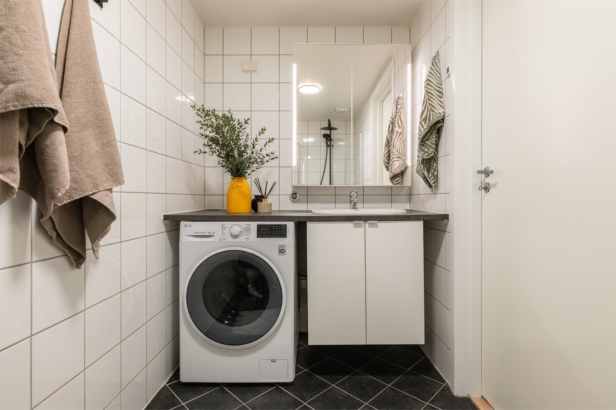 Badet har flislagte overflater, elektrisk gulvvarme og opplegg for vaskemaskin.