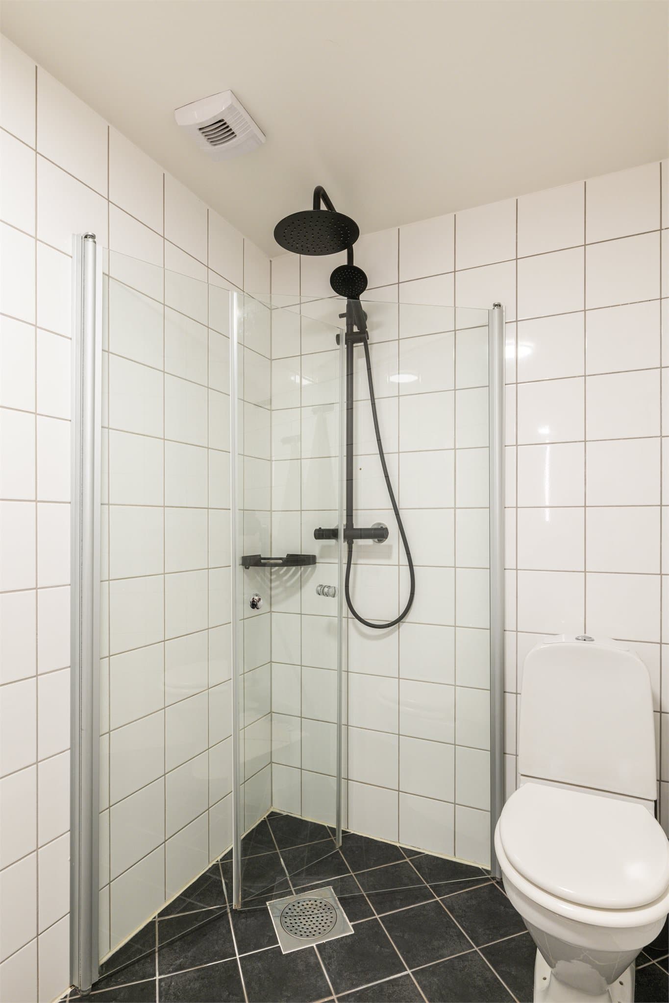 Dusjhjørne med svingbare glassdører. Blandebatteri og dusjarmatur ble byttet i 2020.