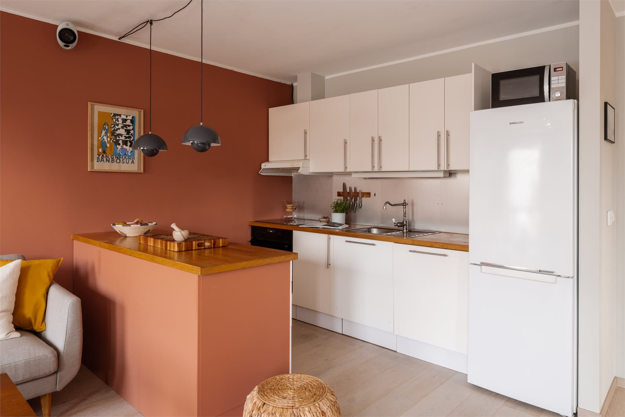 Kjøkkeninnredning med glatte fronter, heltre benkeplate og integrerte hvitevarer.