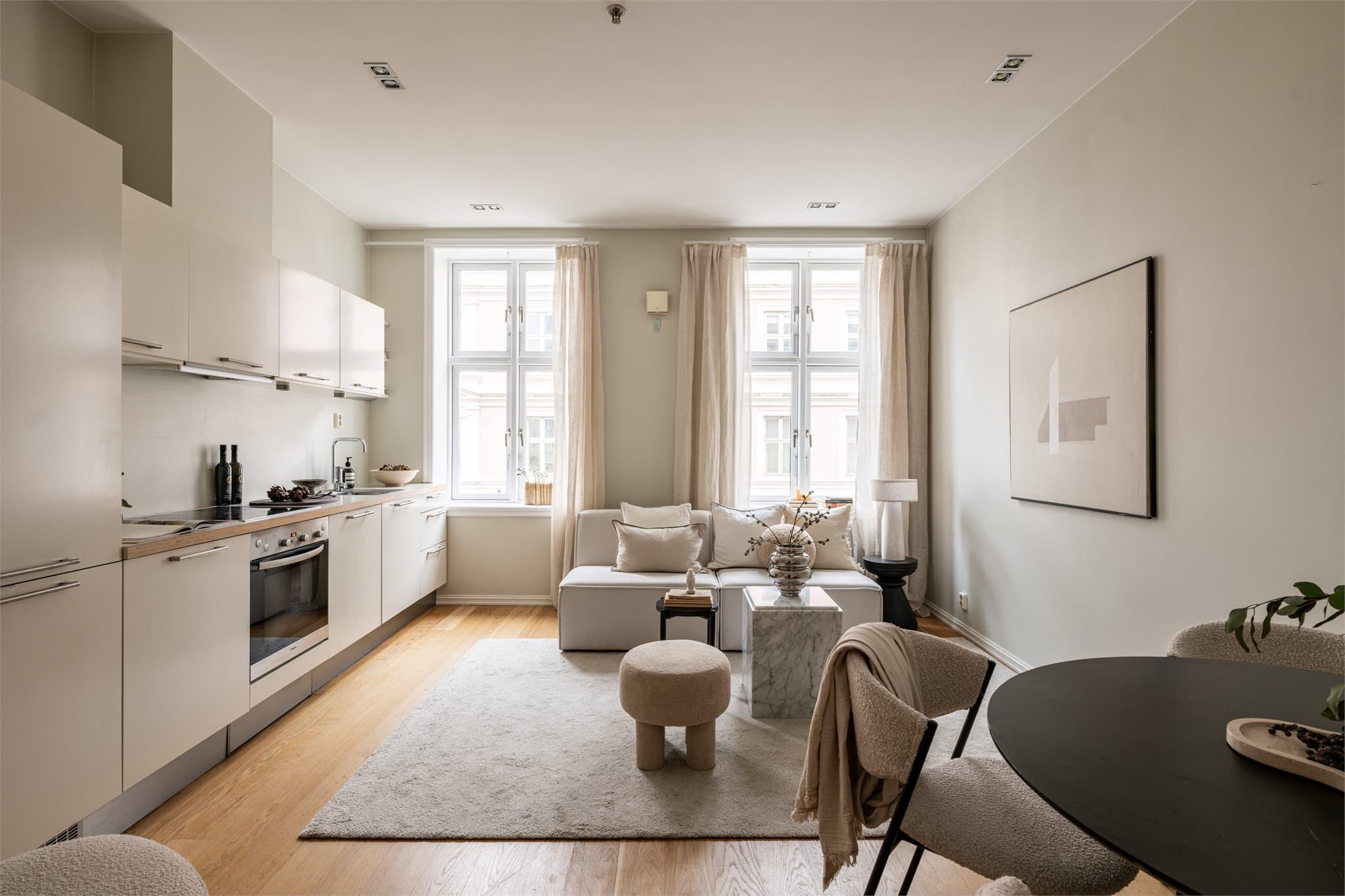 Leilighetens sosiale sone er stuen med åpen kjøkkenløsning. Takhøyden på 2,83 meter gir en luftig og åpen atmosfære.