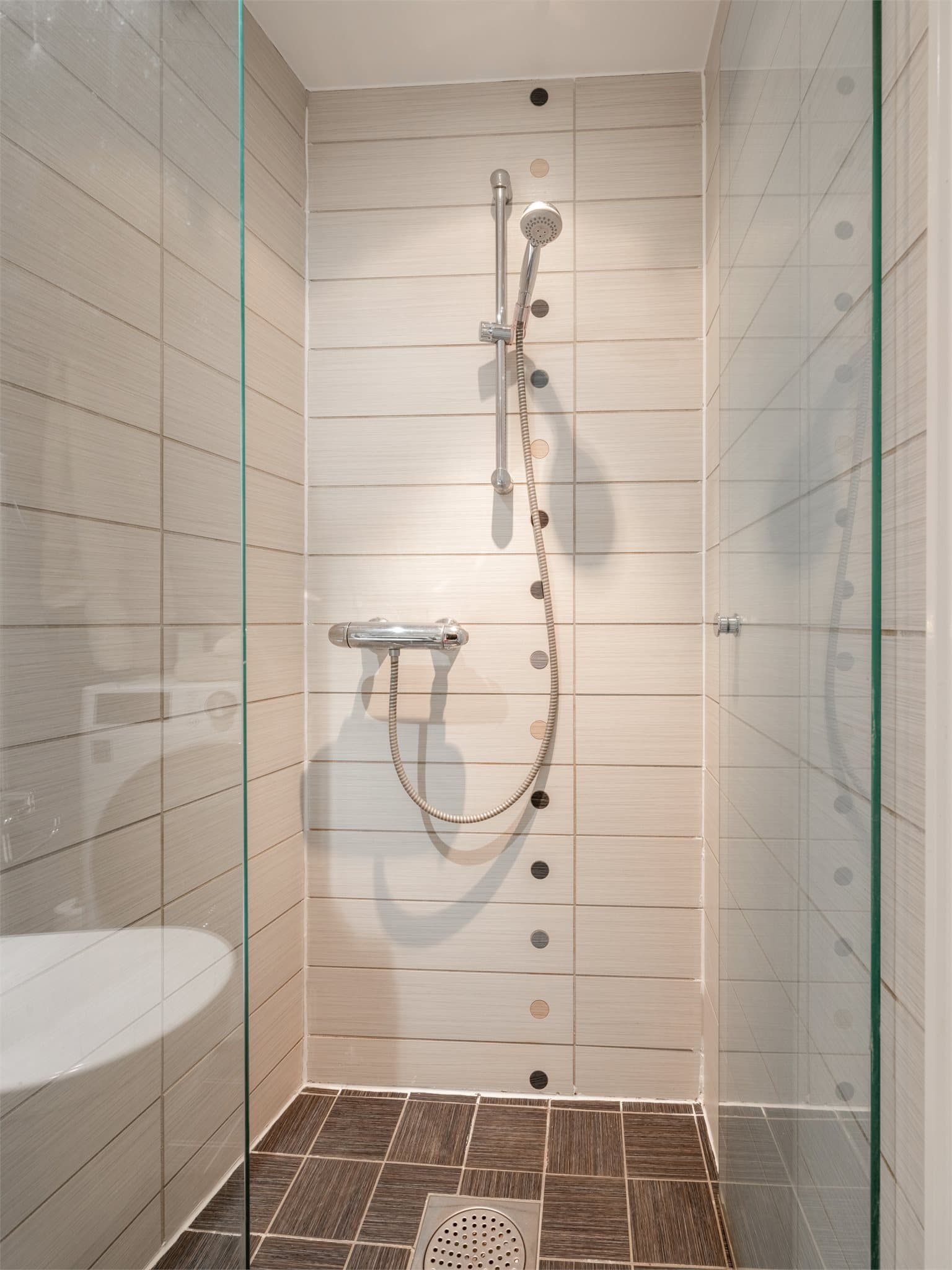 Dusjhjørnet har svingbare glassdører som utnytter plassen effektivt.