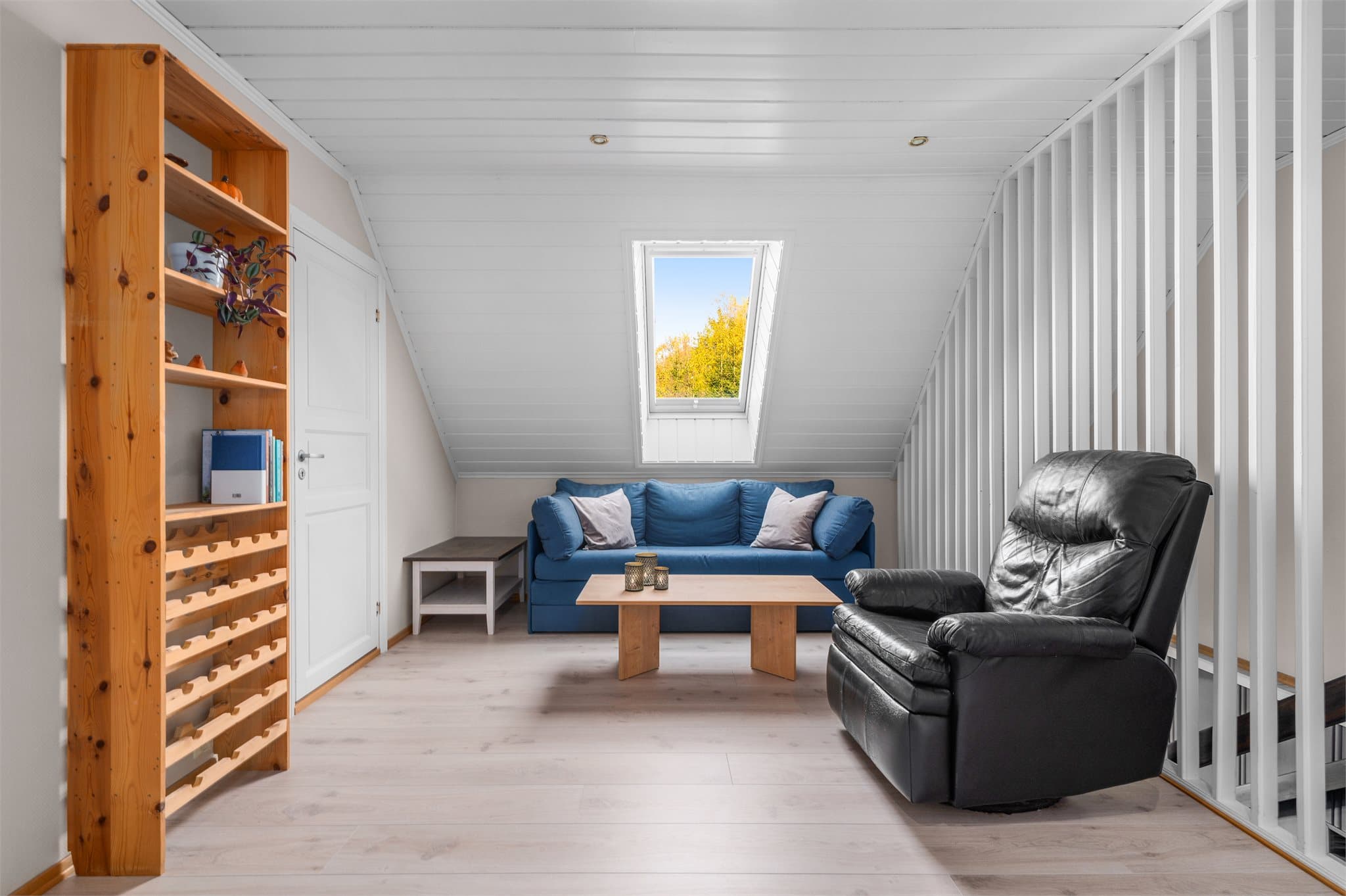 Boligen har også en loftstue som er innredet med en hyggelig sittegruppe. Skråtaket gir rommet karakter.