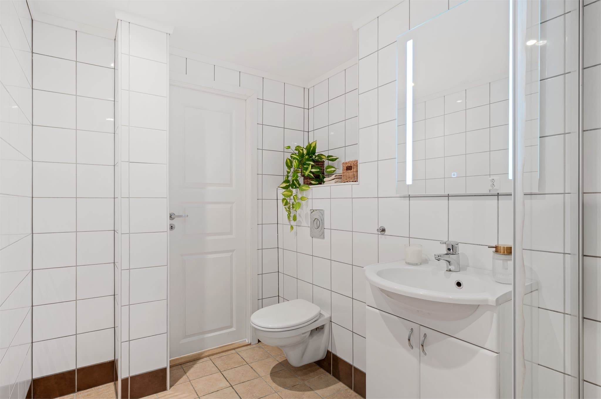 - Badet inneholder et vegghengt toalett, bankeskap m/ servant og dusjhjørne -