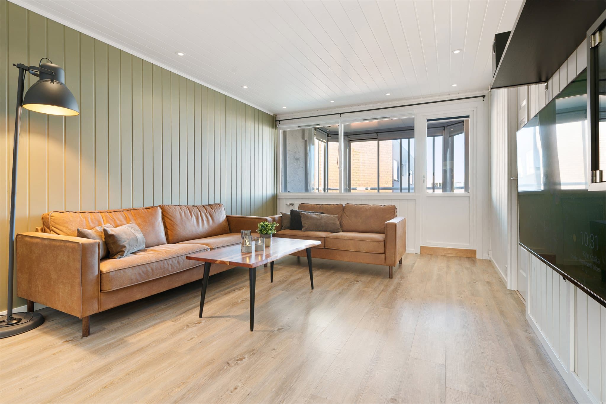 Stuen er malt i tidsriktige fargetoner og har downlightsbelysning i himlingen.