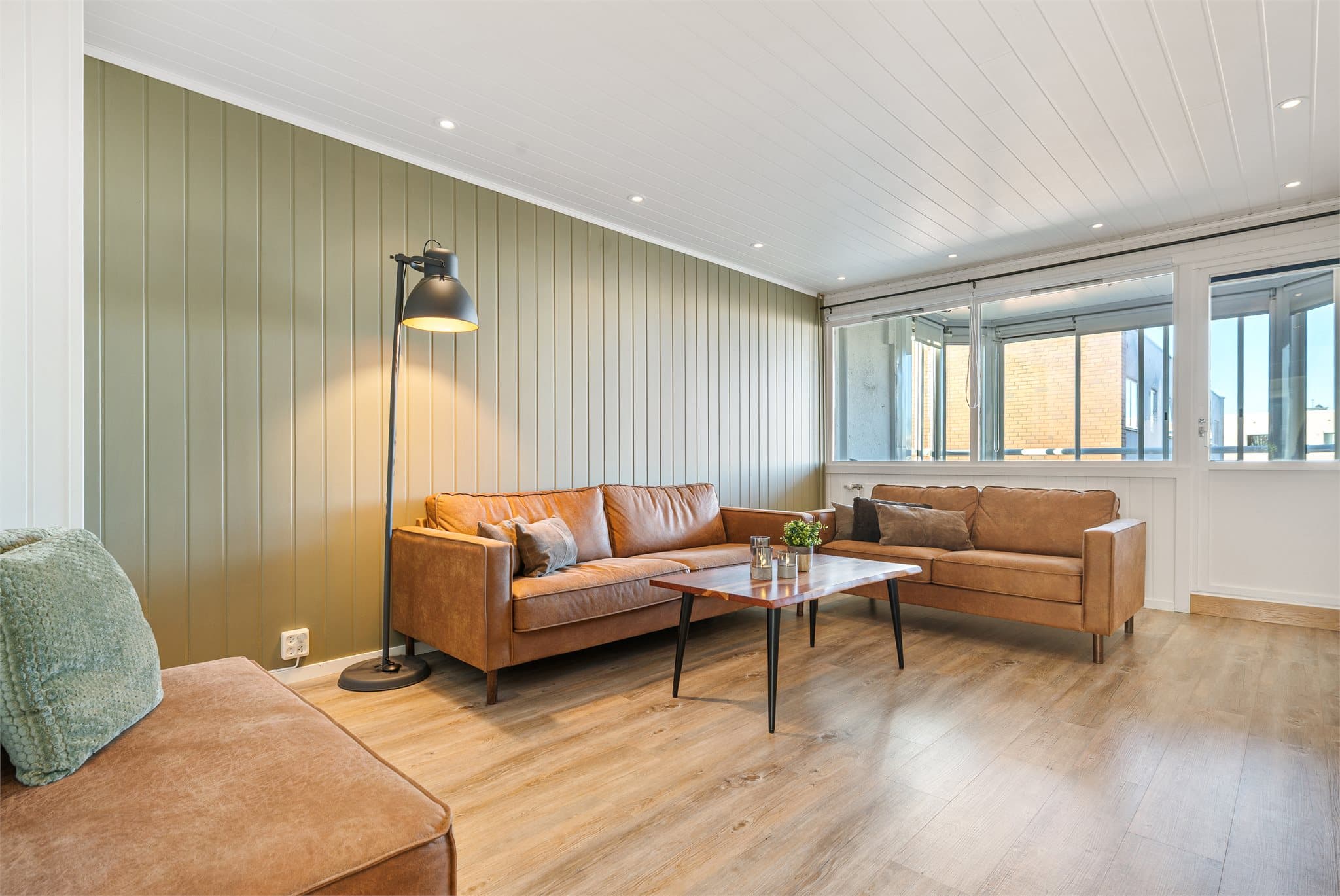 De gode vindusflatene sørger for rikelig med naturlig dagslys, og rommet er enkelt å møblere med både sofagruppe, spiseplass og øvrig innredning.