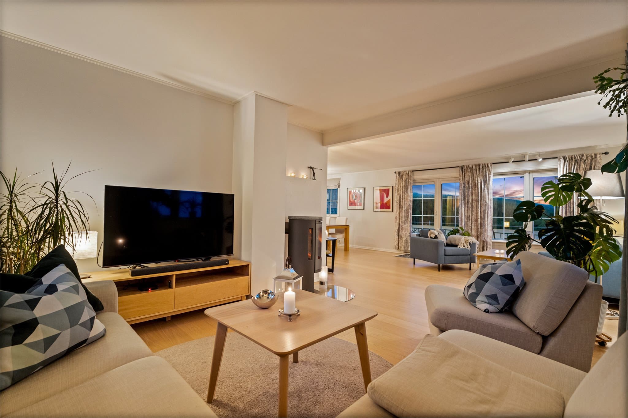 Stuen har en romslig vinkelform med plass til sofagruppe, spisebord og øvrig møblement.
