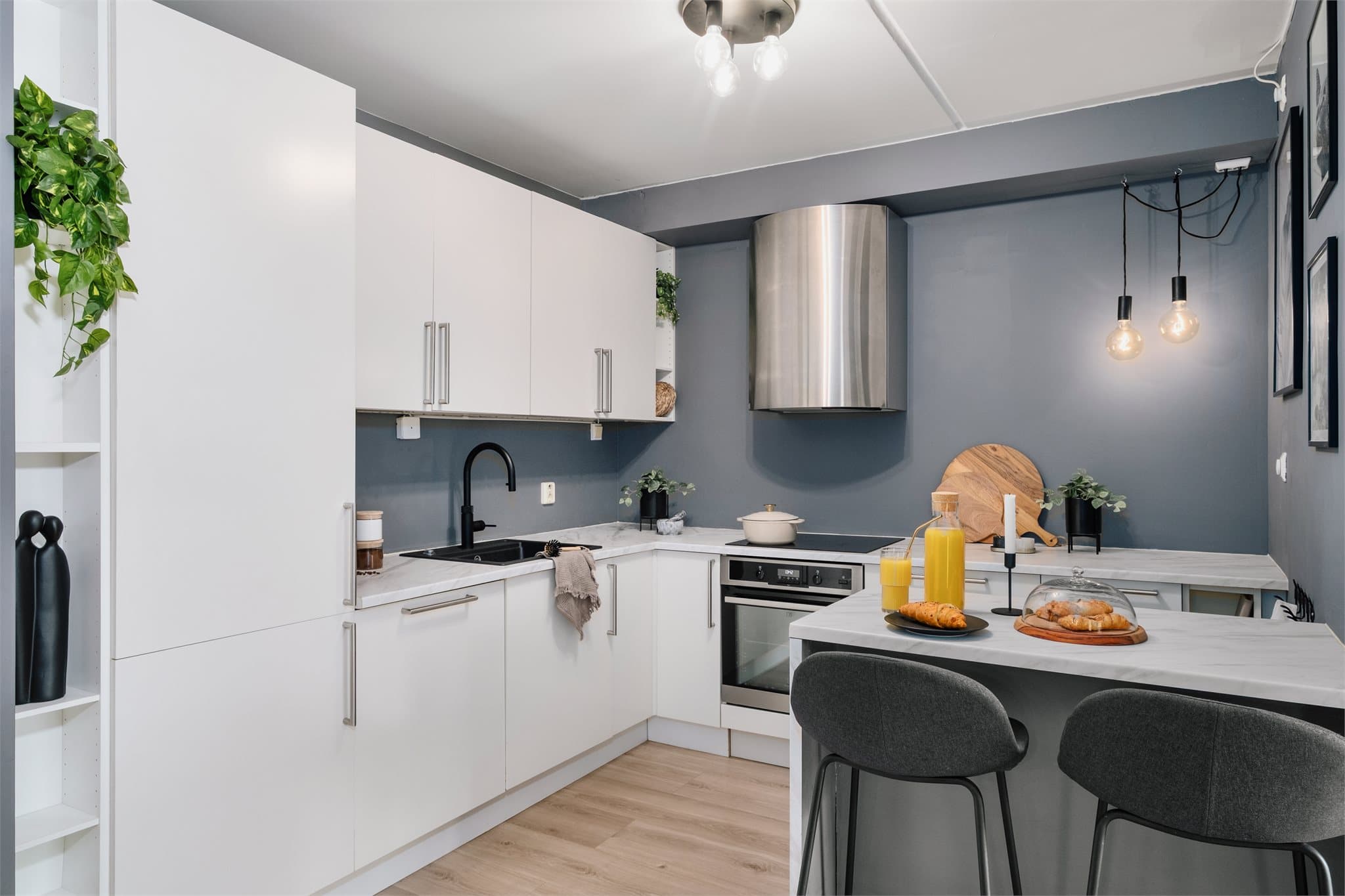 HTH kjøkken med integrerte hvitevarer som stekeovn, platetopp med induksjon, oppvaskmaskin og kjøleskap/frys.