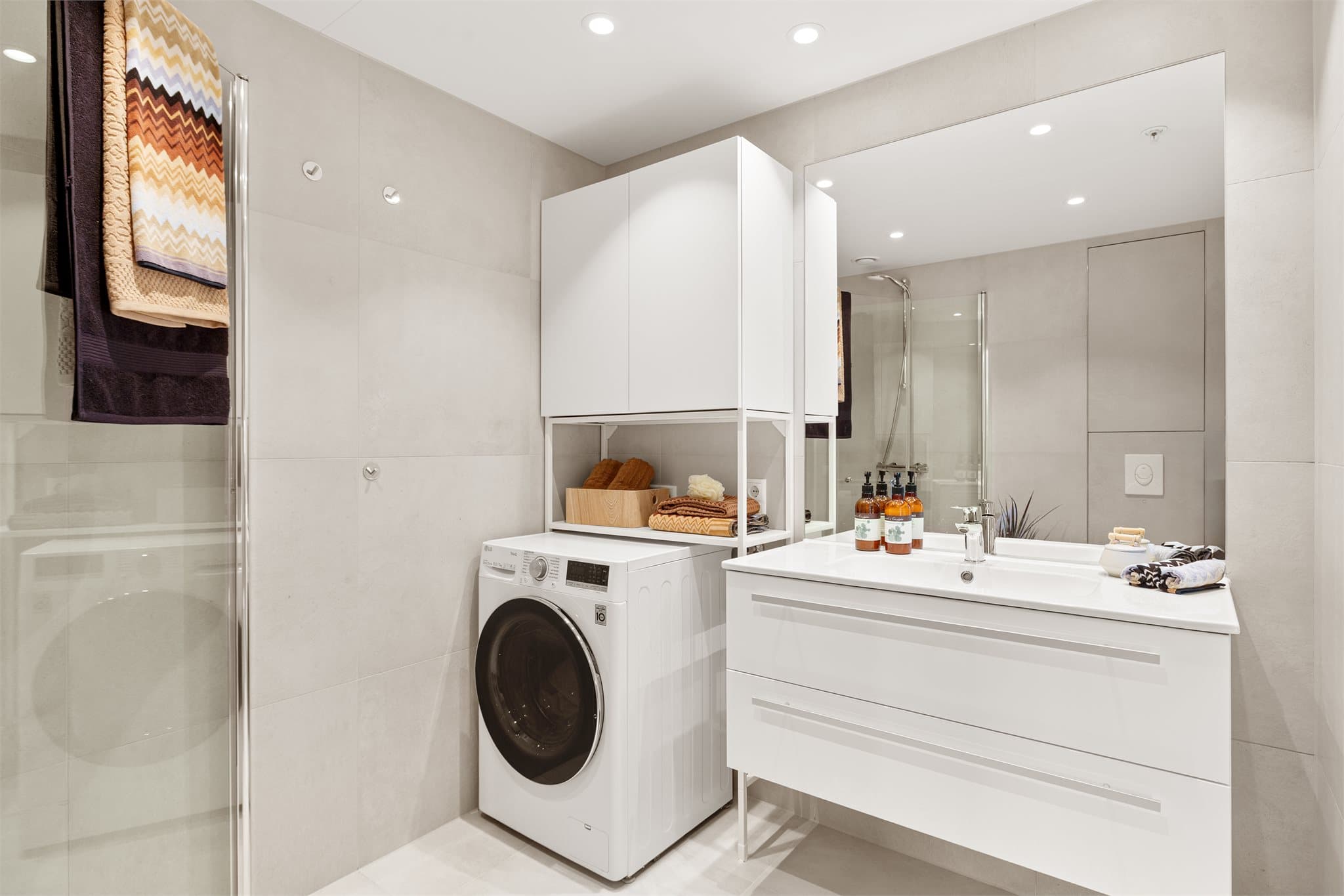 Videre er badet utstyrt med opplegg for vaskemaskin, downlights i himling og et stort speil som bidrar til en romslig følelse.
