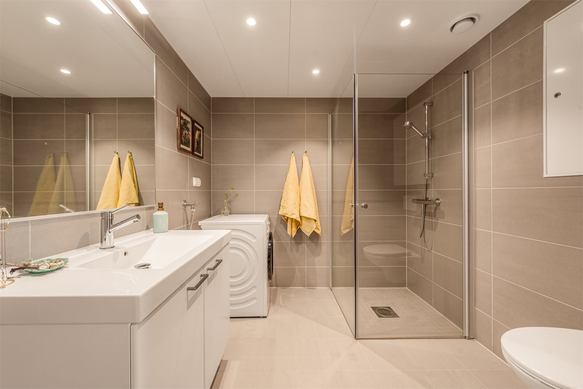 Delikat baderom med flislagte flater og gulvvarme.