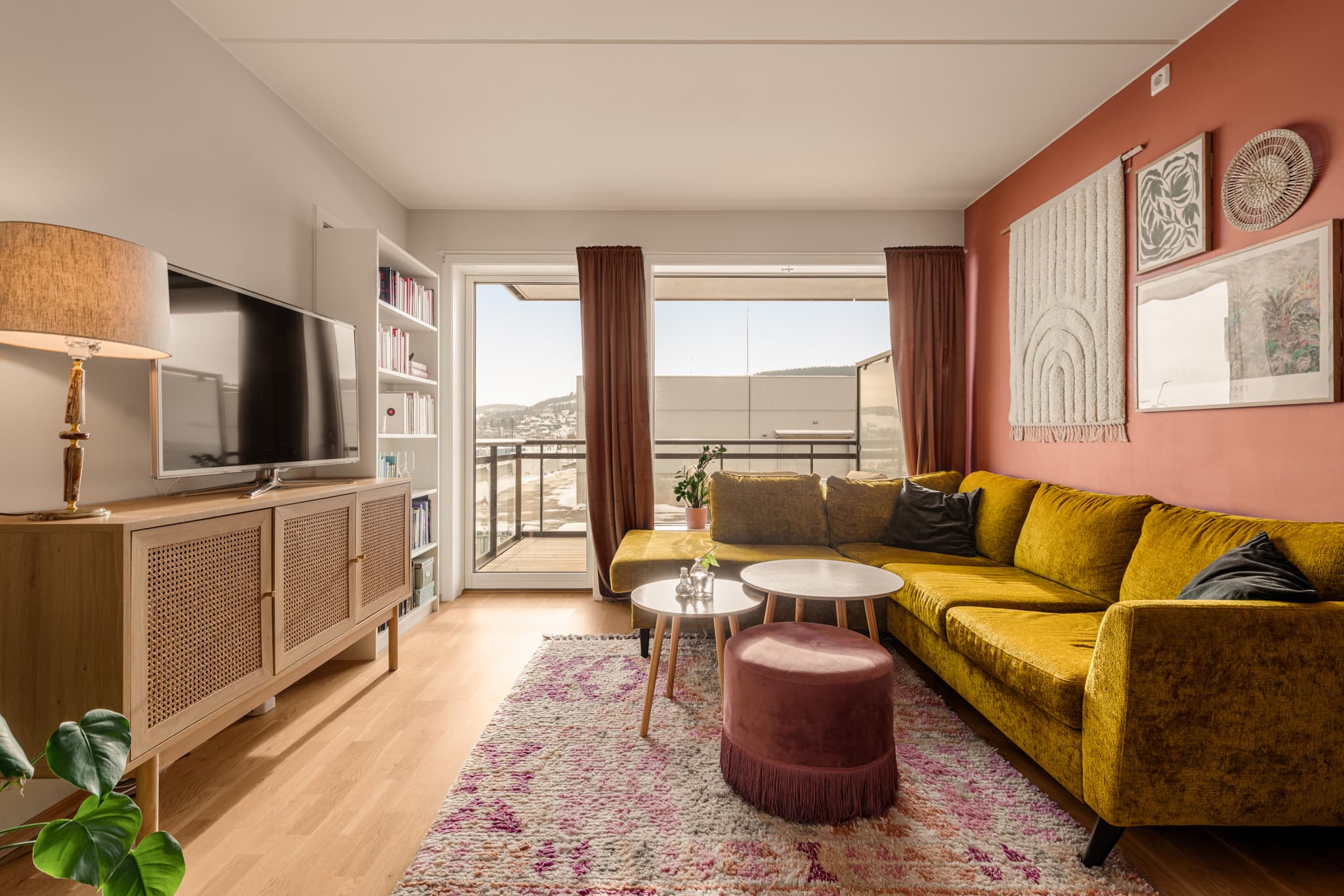 Oppholdsrommet har store vindusflater og utgang til balkong.