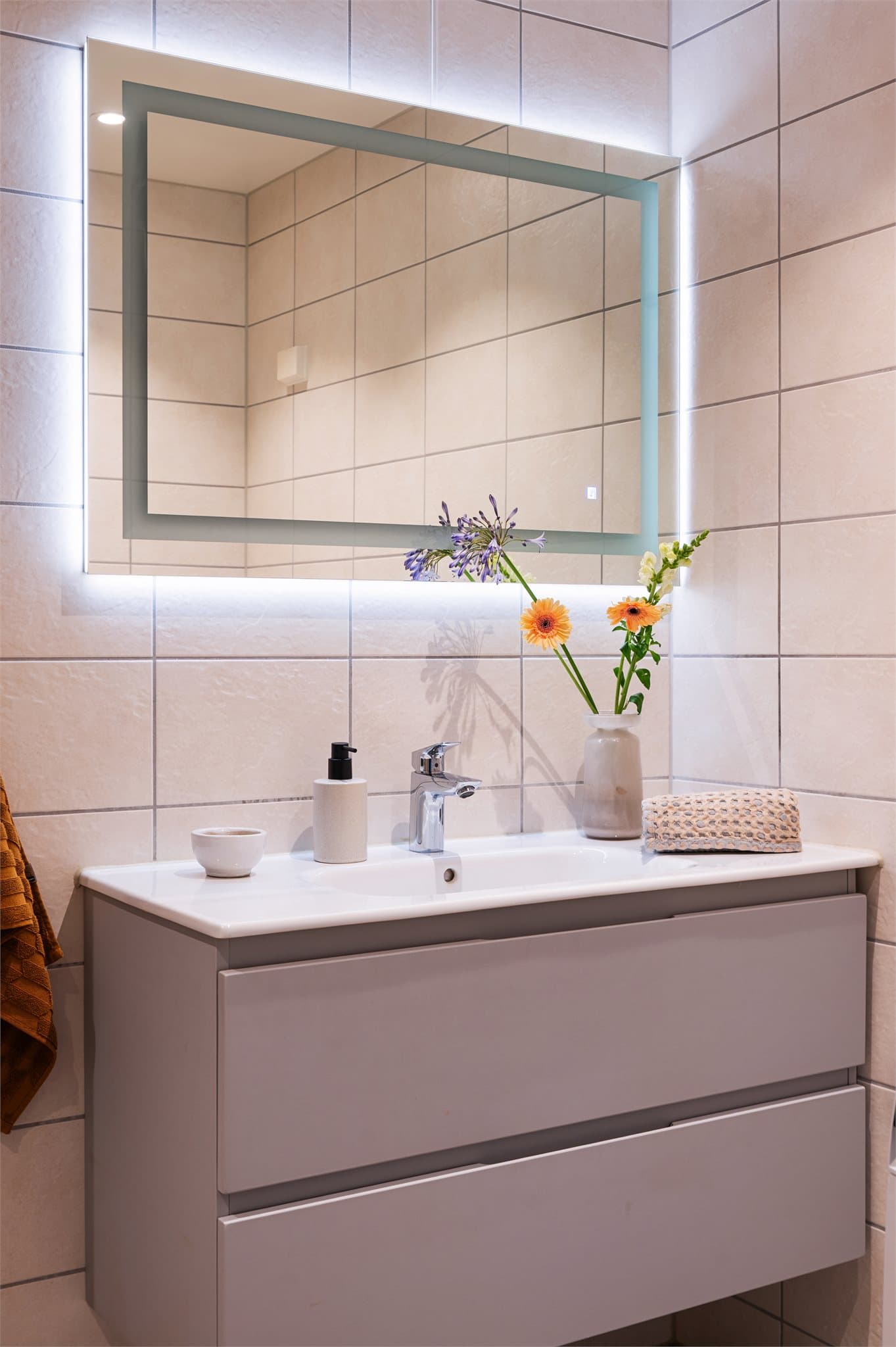 Dusj på gulv med dusjdører i herdet glass. Servant med skuffeinnredning.