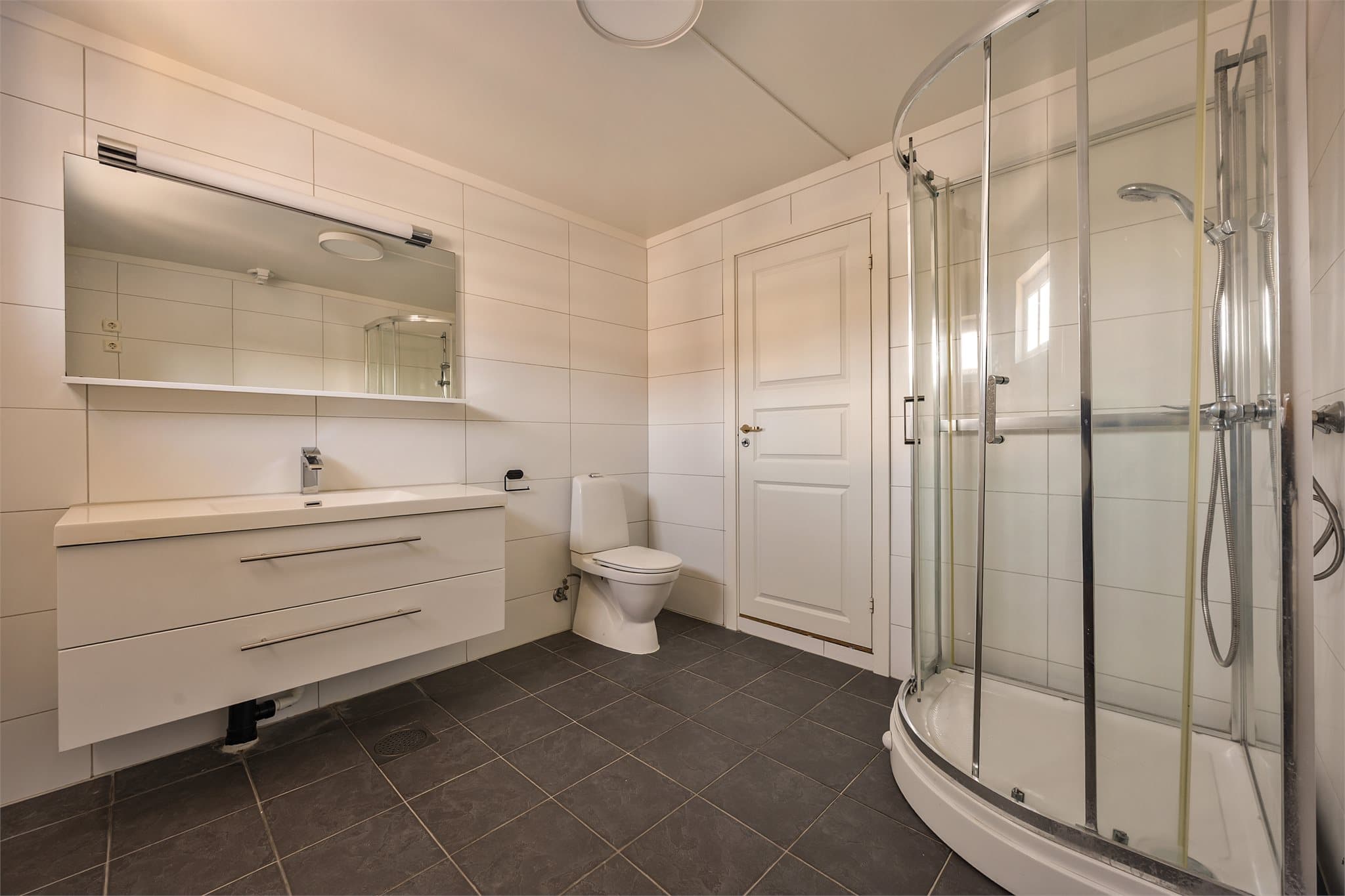 Praktisk utstyrt med dusjkabinett og servantinnredning.