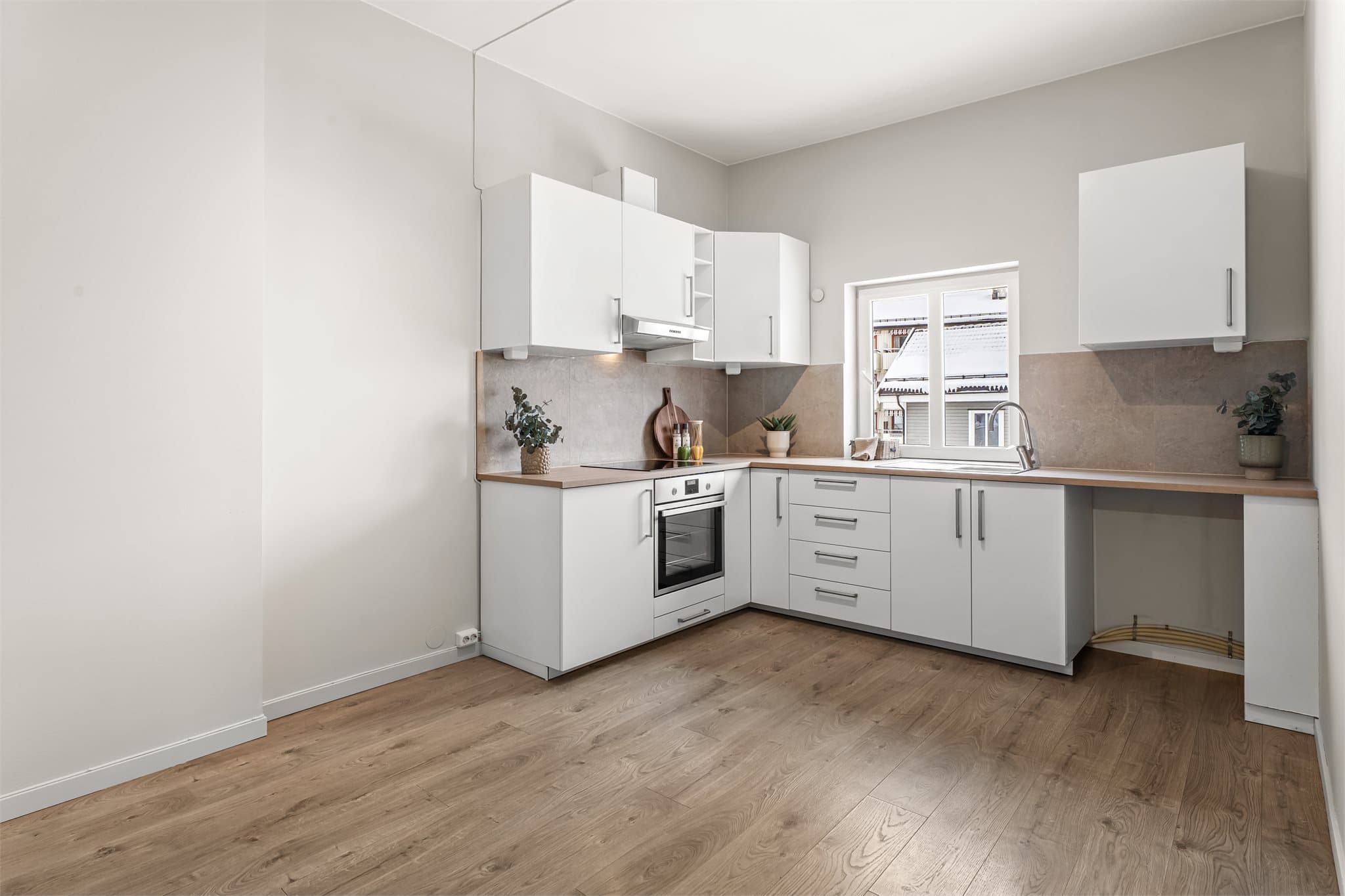 Flislagt vegg og moderne innredning med slette fronter.