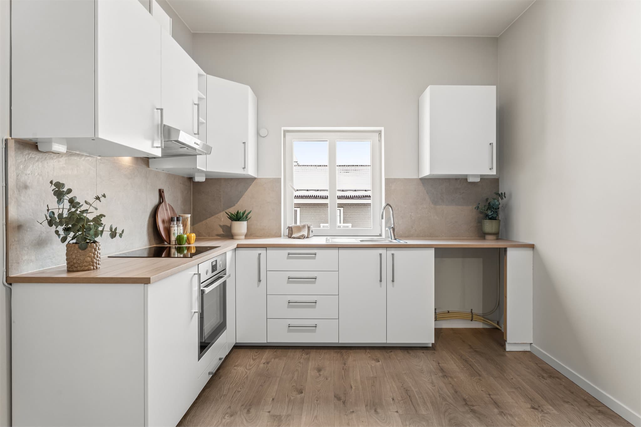 Lyst og funksjonelt kjøkken med integrerte hvitevarer.